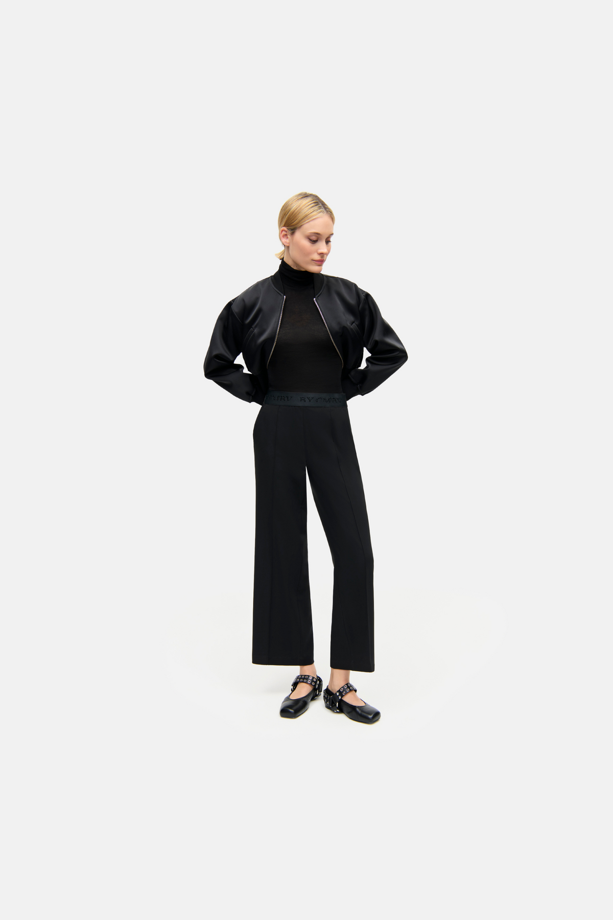 Schwarze Culotte-Hose aus 92 % Polyester und 8 % Polyurethan, Wide-Fit, 7/8 Länge, in einem minimalistischen Studio-Szenario.