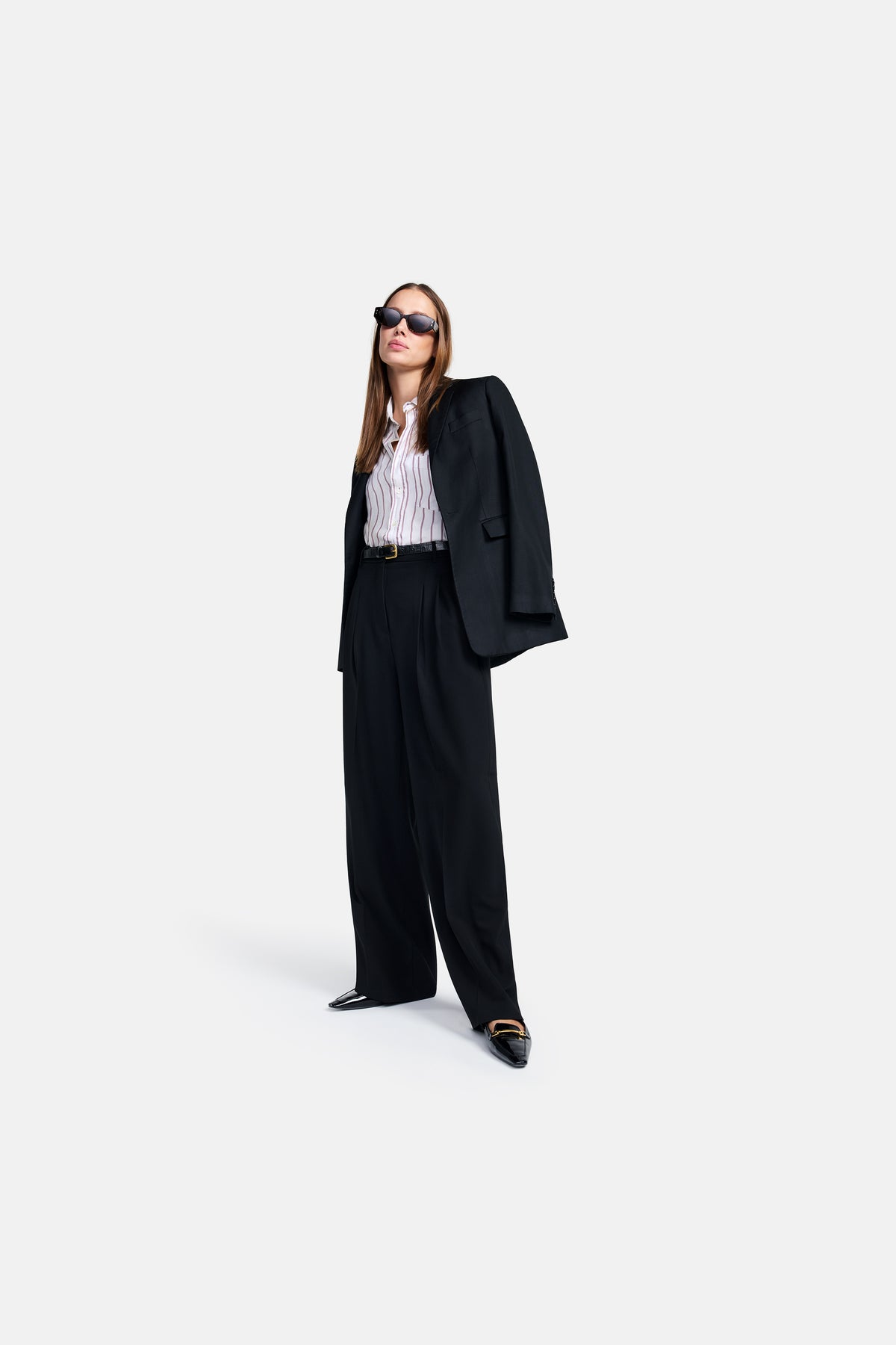Schwarze Hose in A-Shape Silhouette aus 90% Polyester und 10% Polyurethan, getragen von einer Frau mit Sonnenbrille.