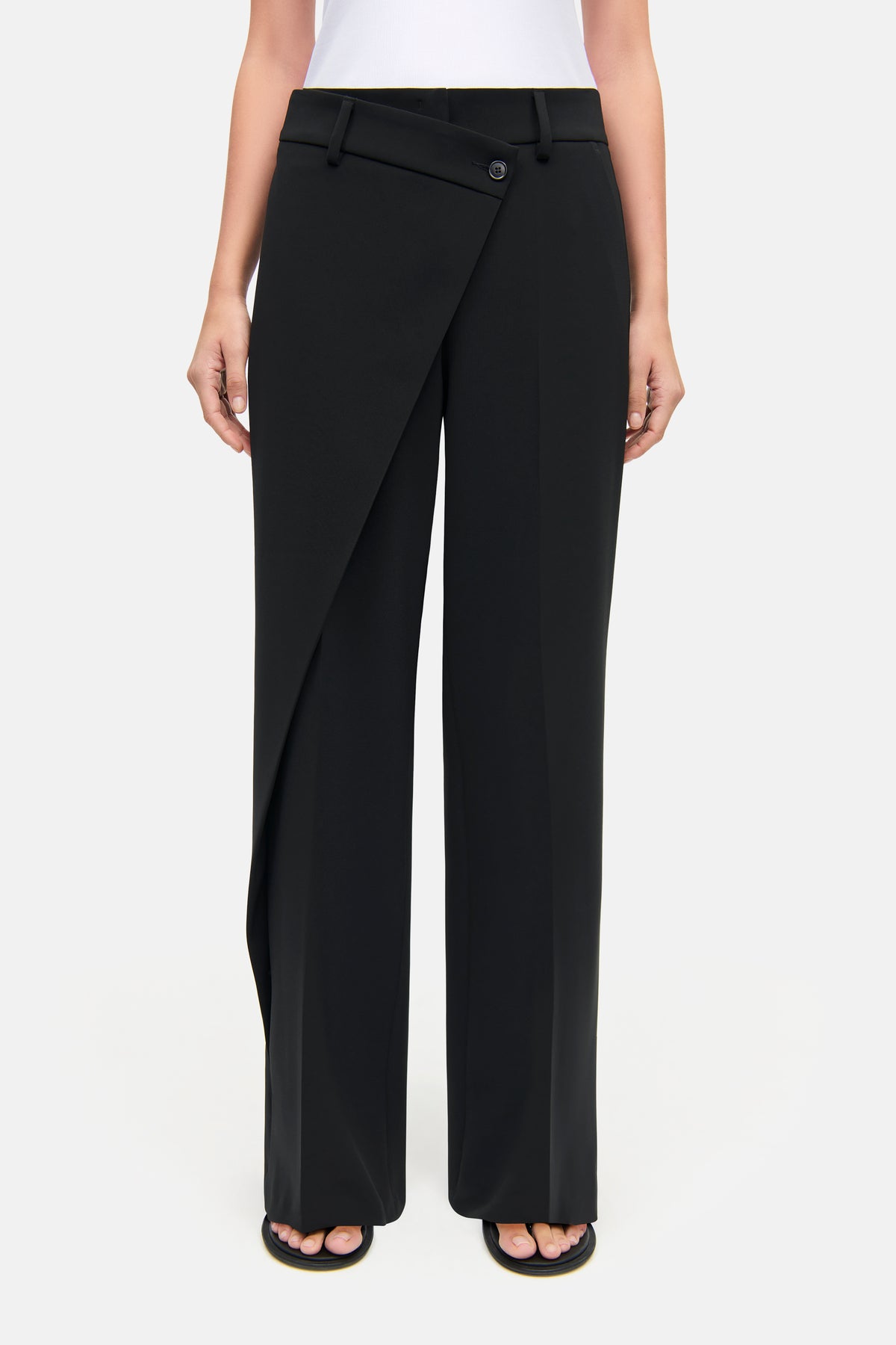 Schwarze Wide-Leg-Hose in voller Länge aus 90 % Polyester und 10 % Polyurethan getragen in einem Studio-Setting.