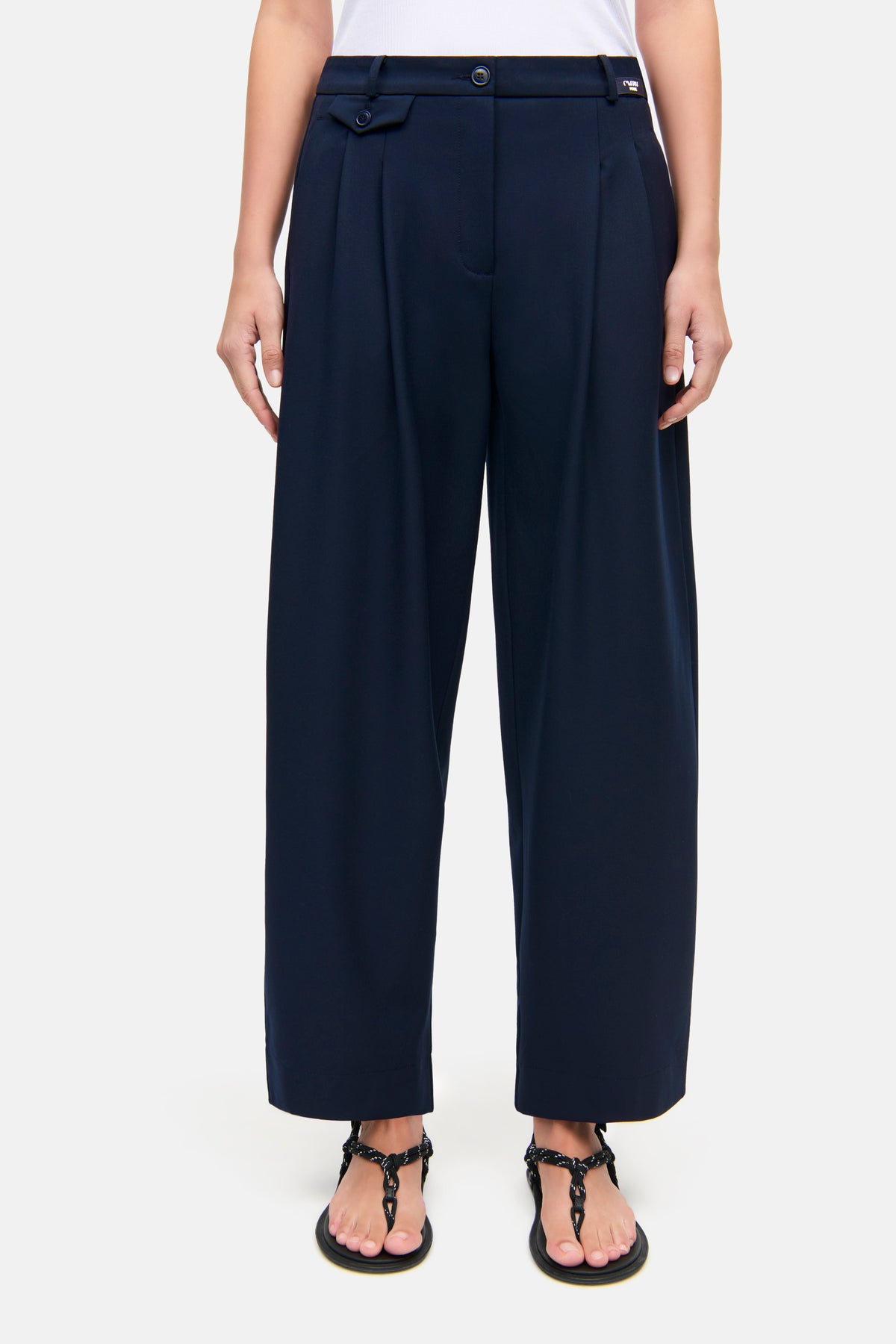 Dunkelblaue O-Shape-Hose aus 67% Polyester, 4% Elasthan, 29% Viskose getragen in einem legeren, sommerlichen Umfeld.
