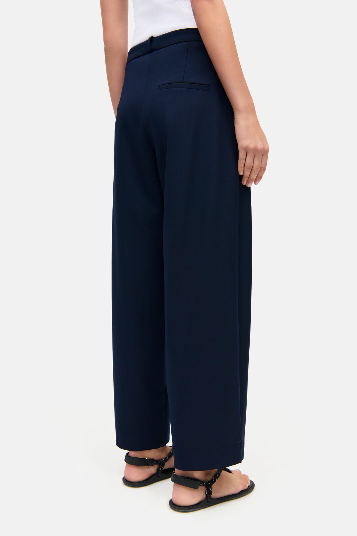 Dunkelblaue O-Shape Hose aus 67% Polyester, 4% Elasthan und 29% Viskose. Getragen in einer lässigen Umgebung mit Sandalen.