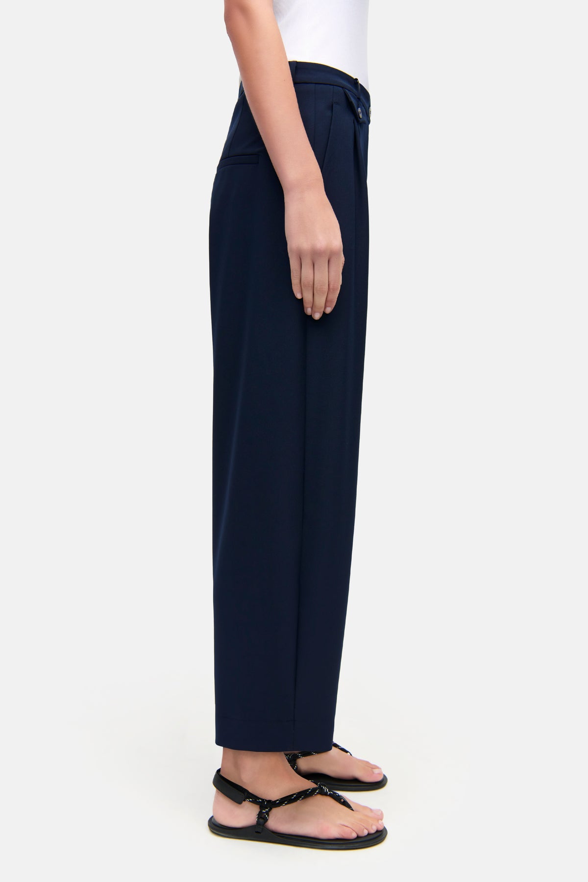 Navyfarbene O-Shape Hose aus 67% Polyester, 4% Elasthan, 29% Viskose, getragen von einer Person in Sandalen.