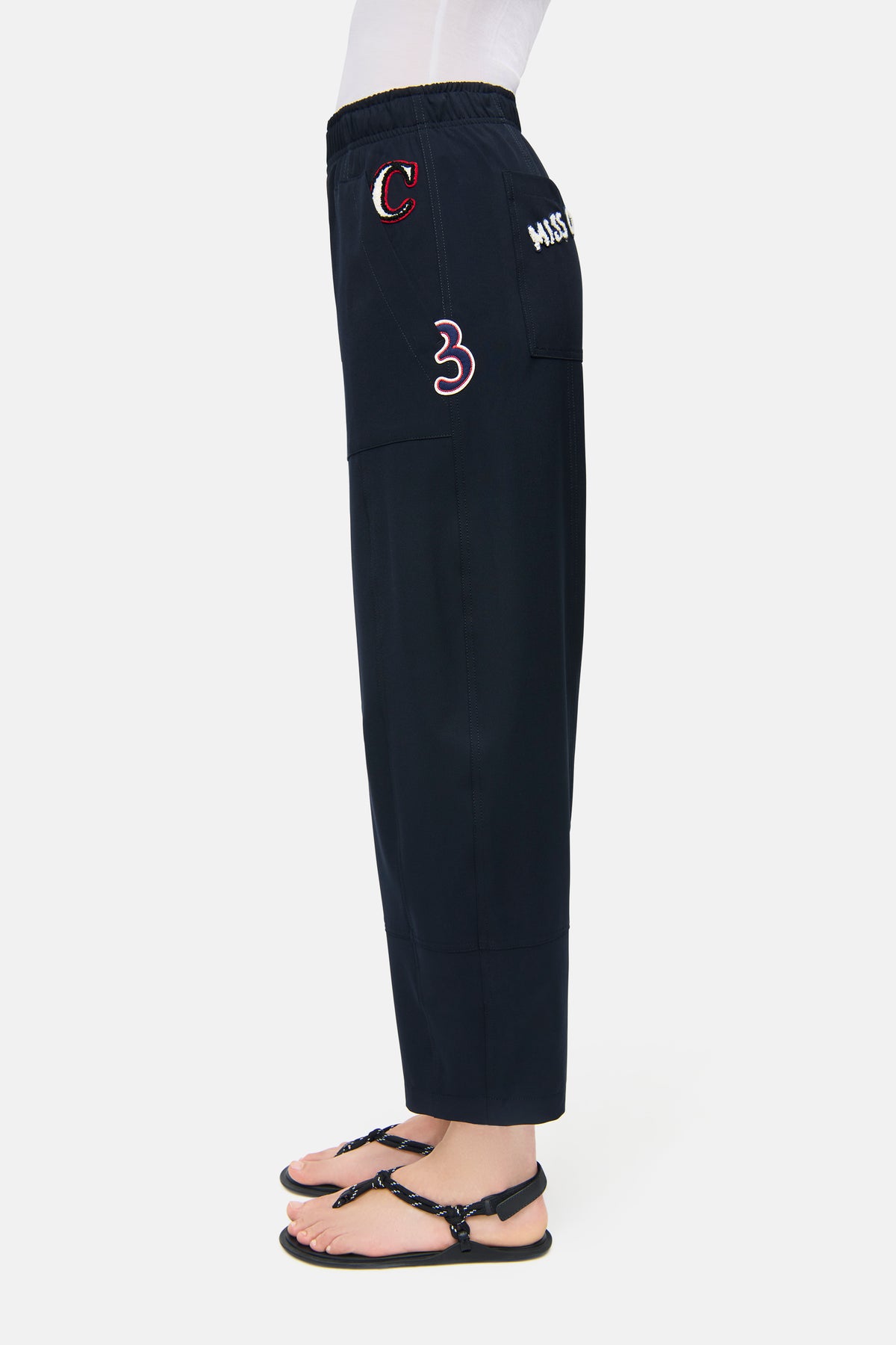 Navyfarbene O-Shape Hose aus 67% Polyester, 4% Elasthan und 29% Viskose. Trägerin trägt Sandalen, entspannte Umgebung.
