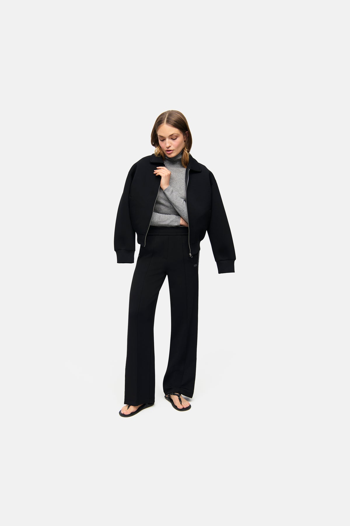 Schwarze weite Hose aus 47% Polyamid, 44% Viskose, 9% Elasthan. Getragen von einer Person in einer lässigen Pose.