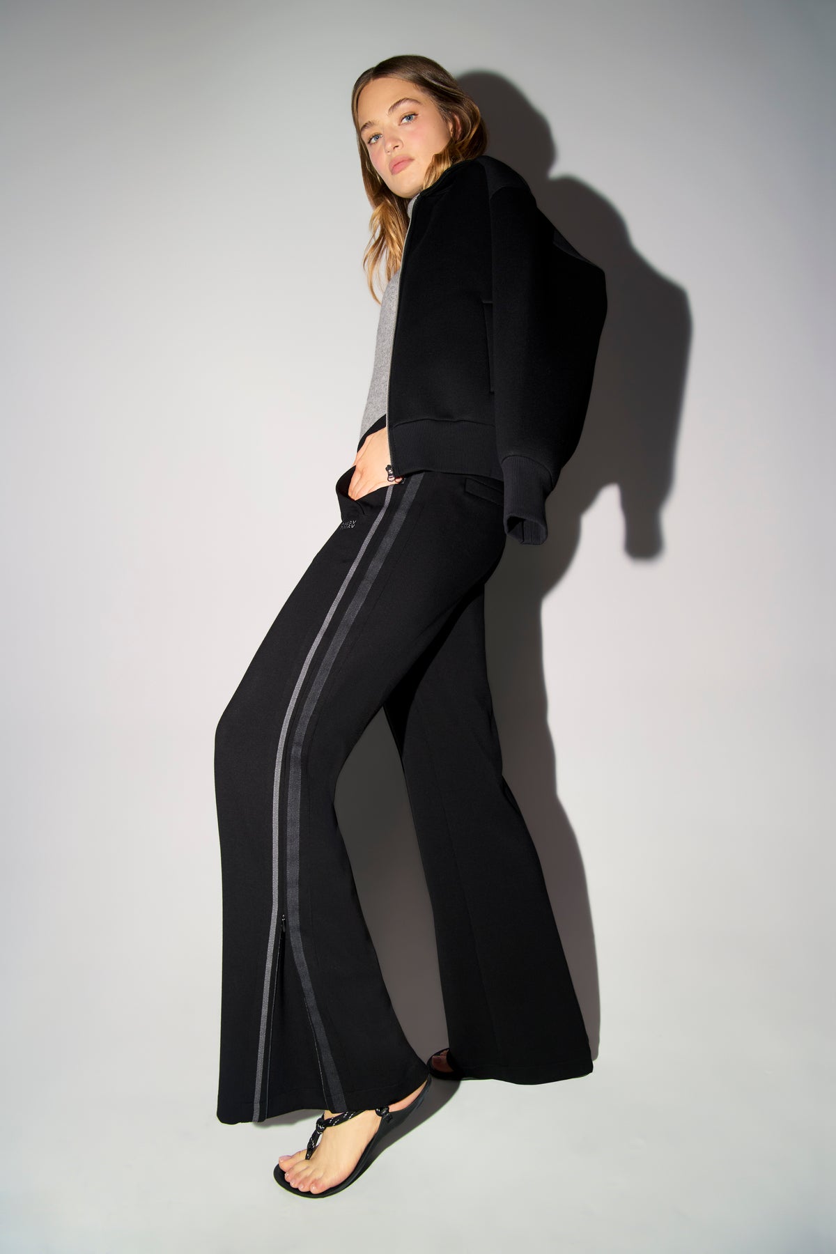 Schwarze Wide Leg Hose aus 47% Polyamid, 44% Viskose, 9% Elasthan. Im urbanen Setting mit sportlich-elegantem Look getragen.