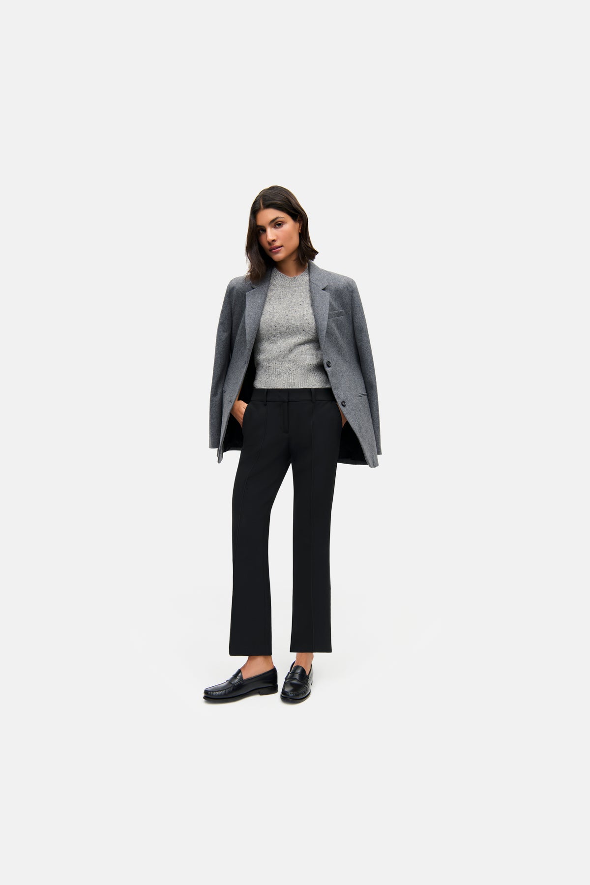 Schwarze Flared-Hose aus 63% Polyester, 27% Viskose, 7% Baumwolle, 3% Elasthan. Frau in Business-Setting mit Blazer.