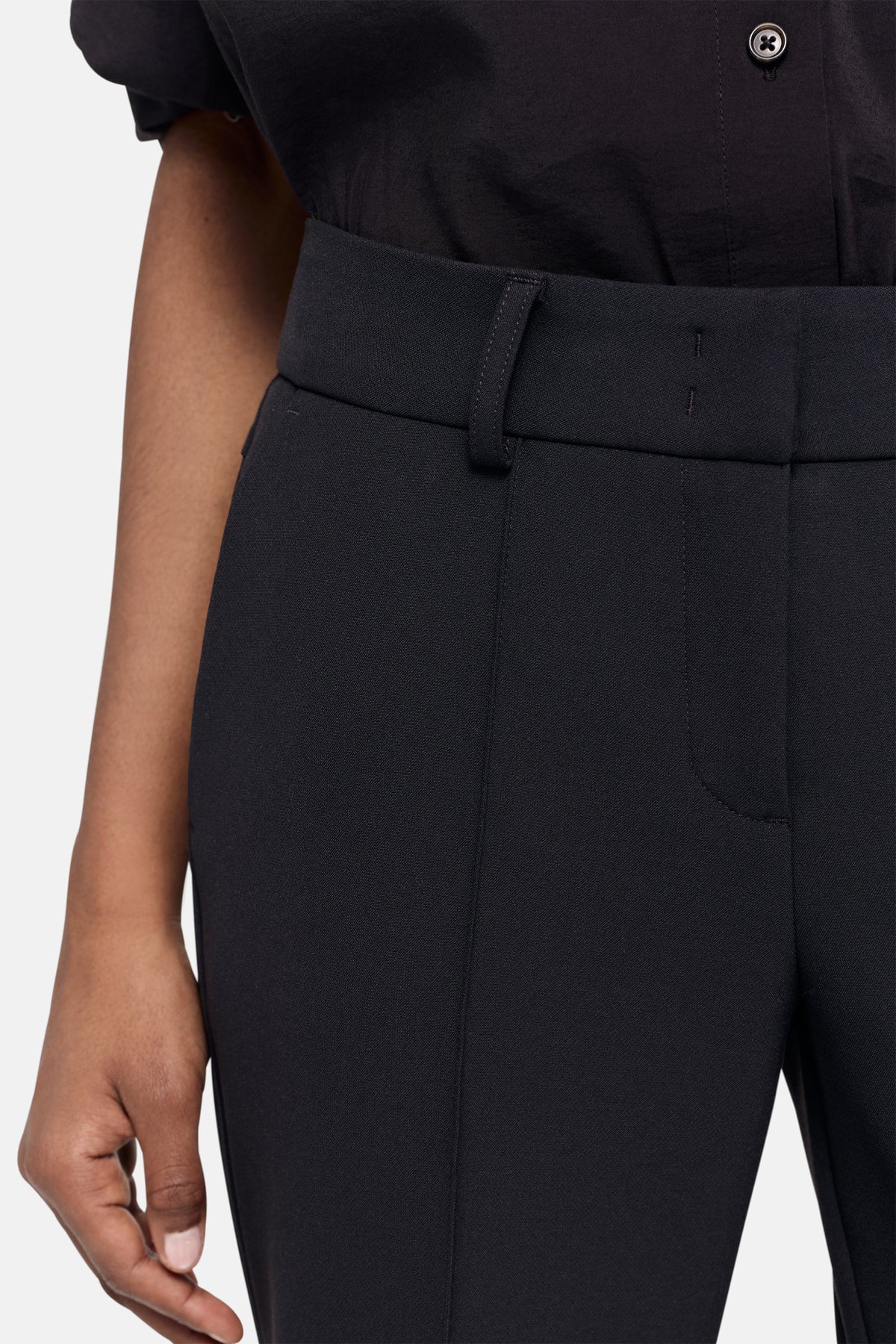 Flared Hose in dunklem Navy; 63% Polyester, 27% Viskose, 7% Baumwolle, 3% Elasthan. Wird von einer Person getragen.