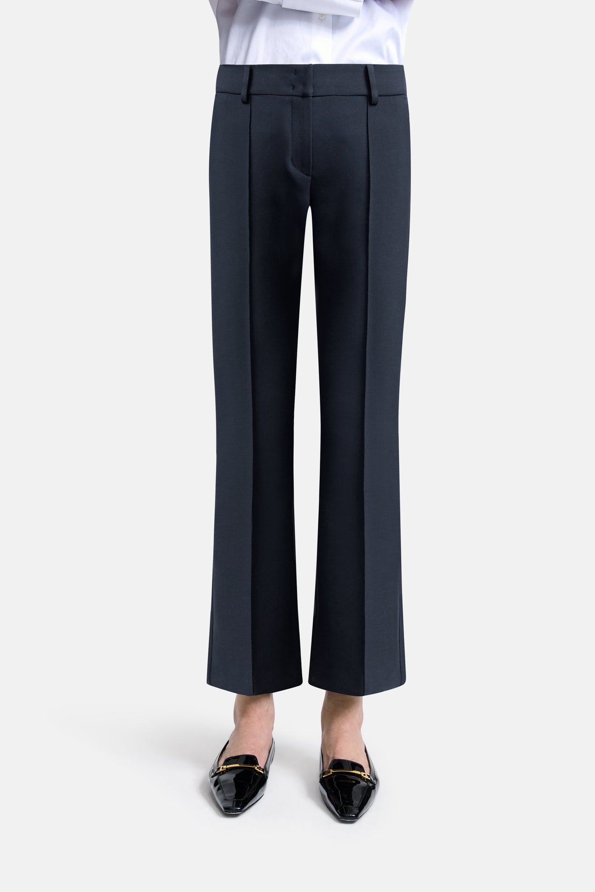 Dunkelblaue Flared-Fit Hose im Cropped-Stil aus 63 % Polyester, 27 % Viskose, 7 % Baumwolle, 3 % Elasthan. Getragen zu Loafers.