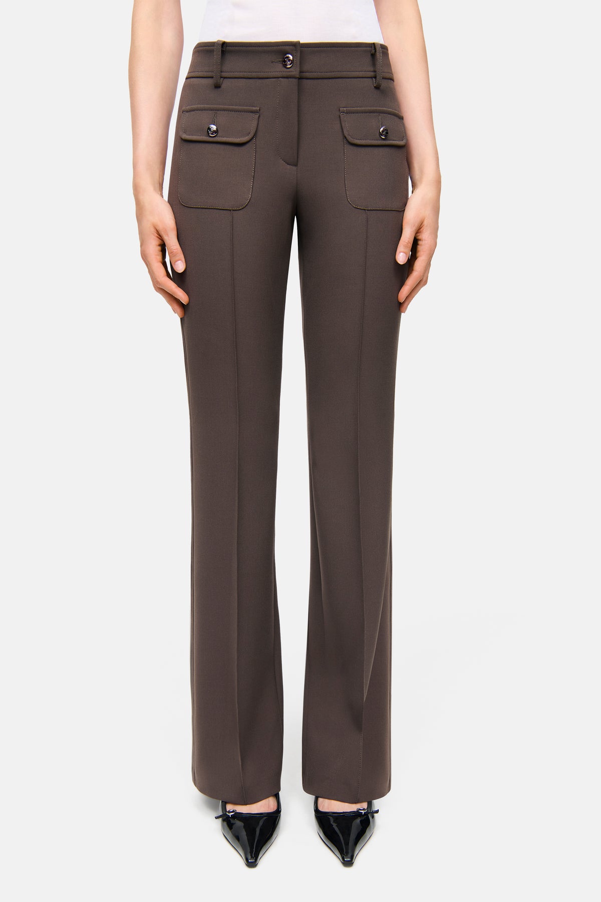 Dunkelbraune Flared-Hose mit silberfarbenen Knöpfen und aufgesetzten Fronttaschen, hergestellt aus Bi-Stretch-Stoff.
