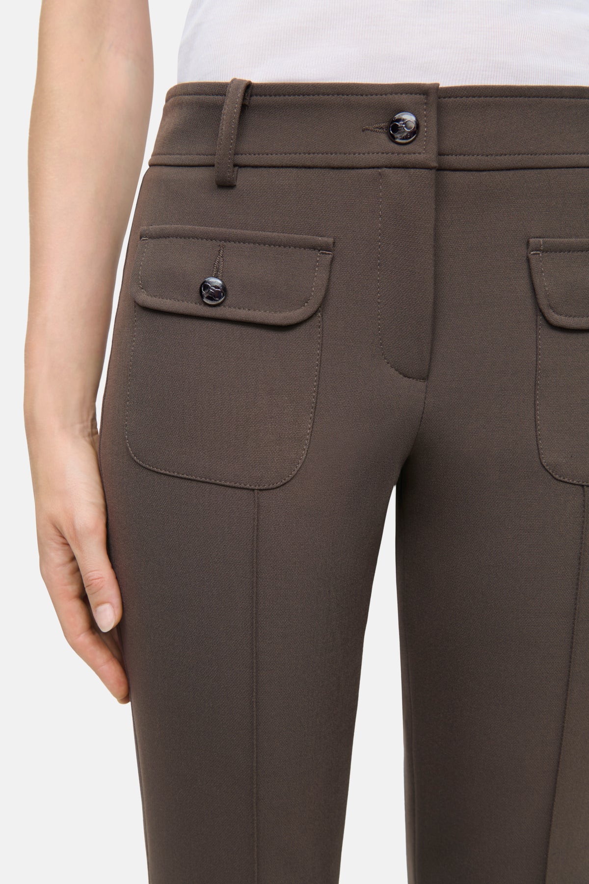 Braune Flared-Hose aus Bi-Stretch-Material, bestehend aus 63% Polyester, 27% Viskose, 7% Baumwolle und 3% Elasthan.
