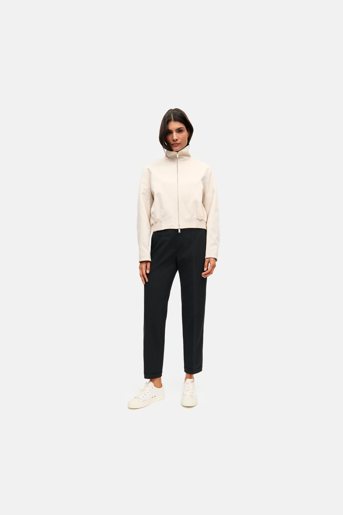 Schwarze Cropped-Hose im Carrot-Fit aus 67% Polyester, 29% Viskose und 4% Elasthan, getragen von einer Person in einem neutralen Setting.