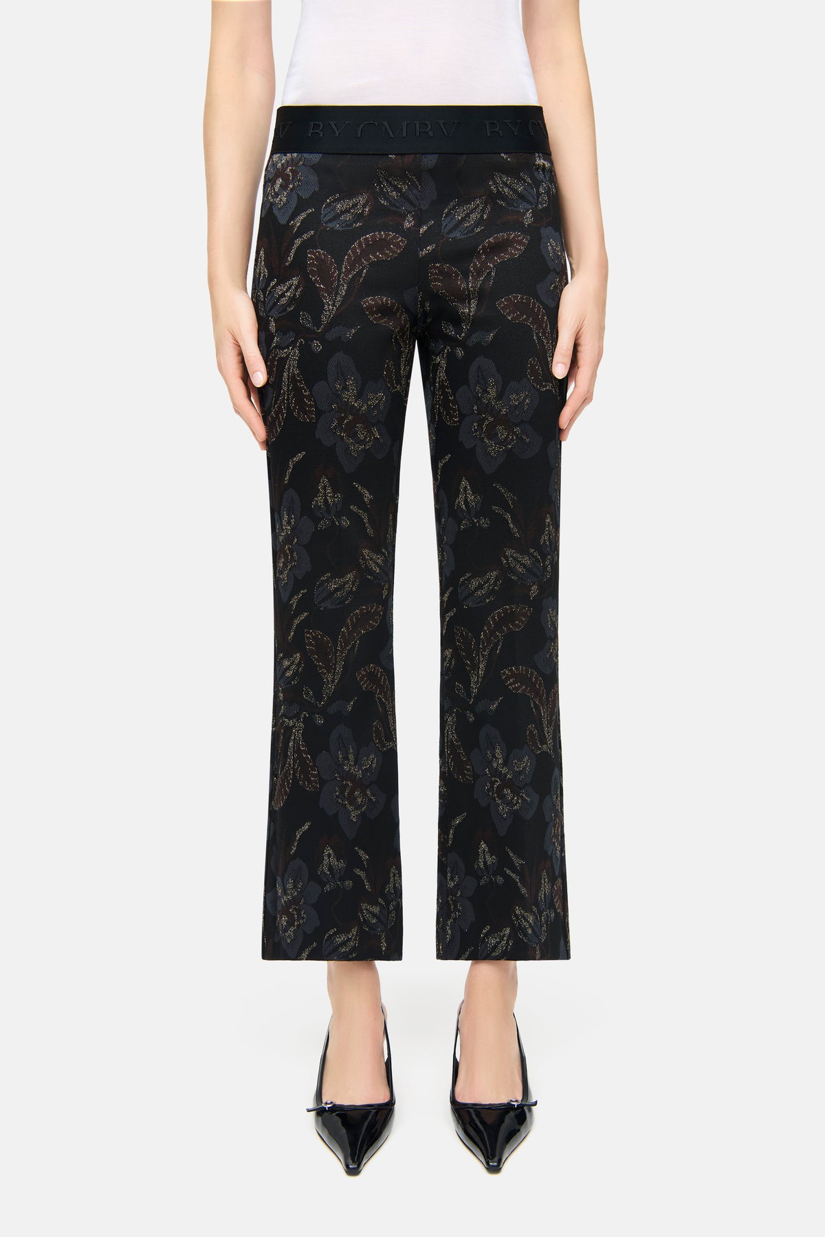 Schwarze Flared Hose aus Flower Lurex Jersey Jacquard mit Blumenmuster in Blau- und Brauntönen, Material: Viskosemischung. Person trägt die Hose.