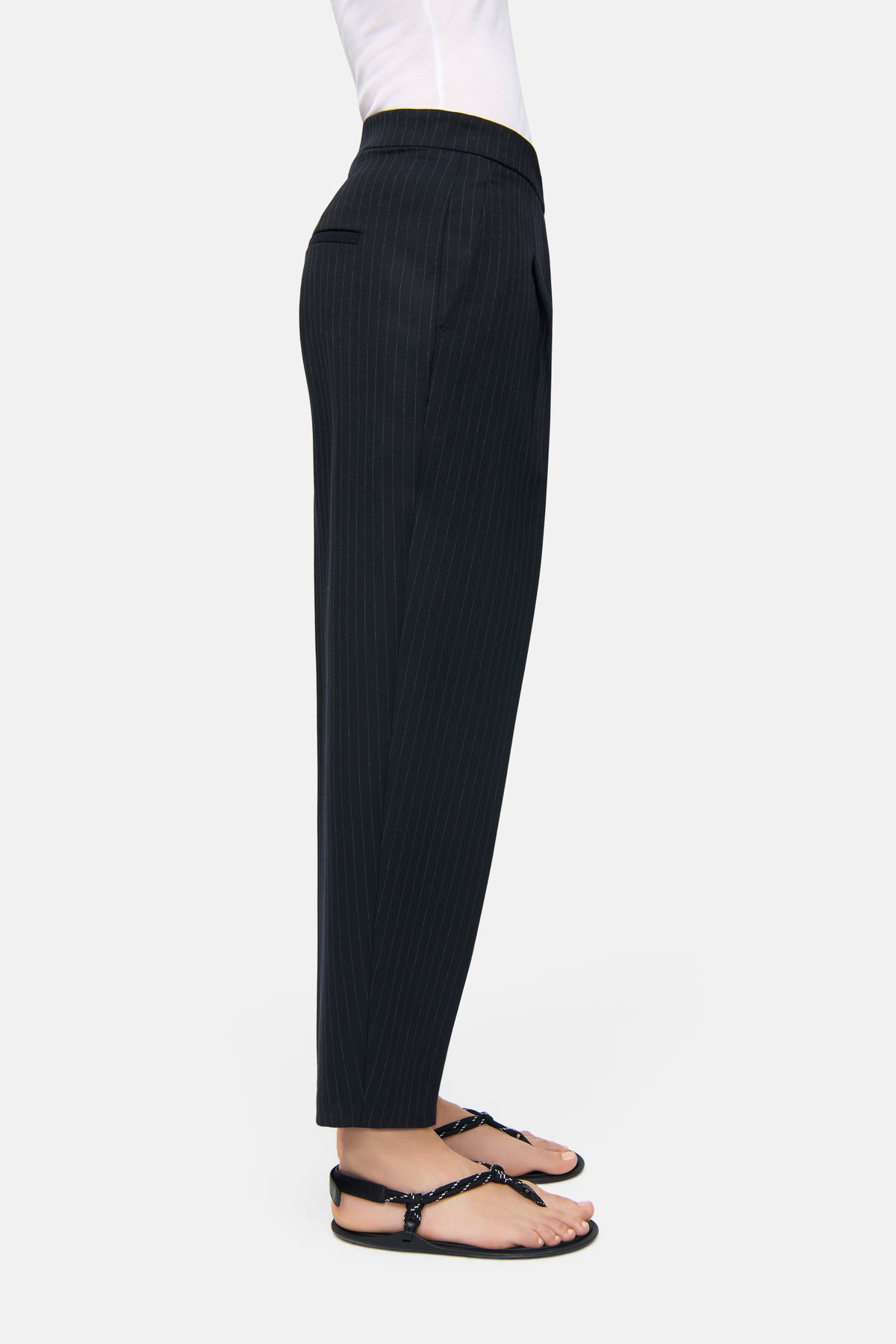 Dunkelblaue Nadelstreifenhose, O-Shape, verkürzte Länge. Material: 62% Polyester, 26% Viskose, 9% Wolle, 3% Elasthan.