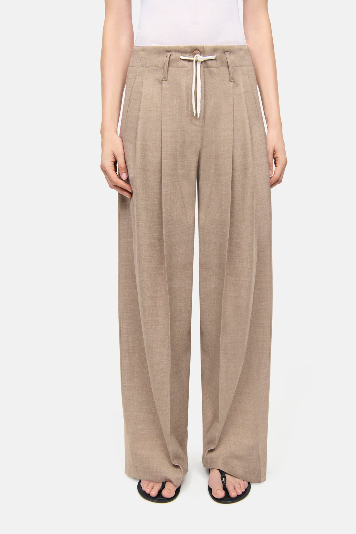 Camel-melange-farbene Wide-Leg-Hose ADDISON aus einem Woll-Mix-Gabardine; Material: 53% Polyester, 43% Schurwolle, 4% Elasthan. Getragen in einem lässigen Alltagssetting.