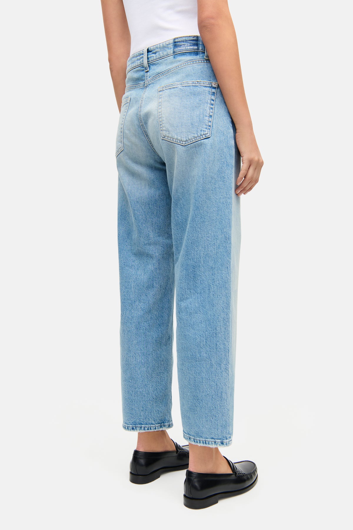 Hellblaue Straight-Fit Jeans aus 98% Baumwolle und 2% Elasthan, im 5-Pocket-Design. Getragen in urbanem Setting.