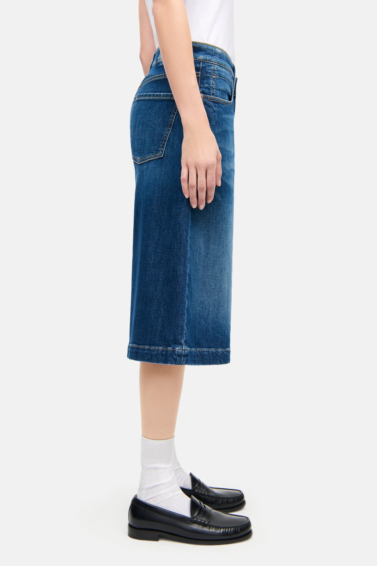 Blaue Palazzo-Jeans-Bermuda aus 98 % Baumwolle und 2 % Elasthan, getragen von einer Person in lässigem Outfit.