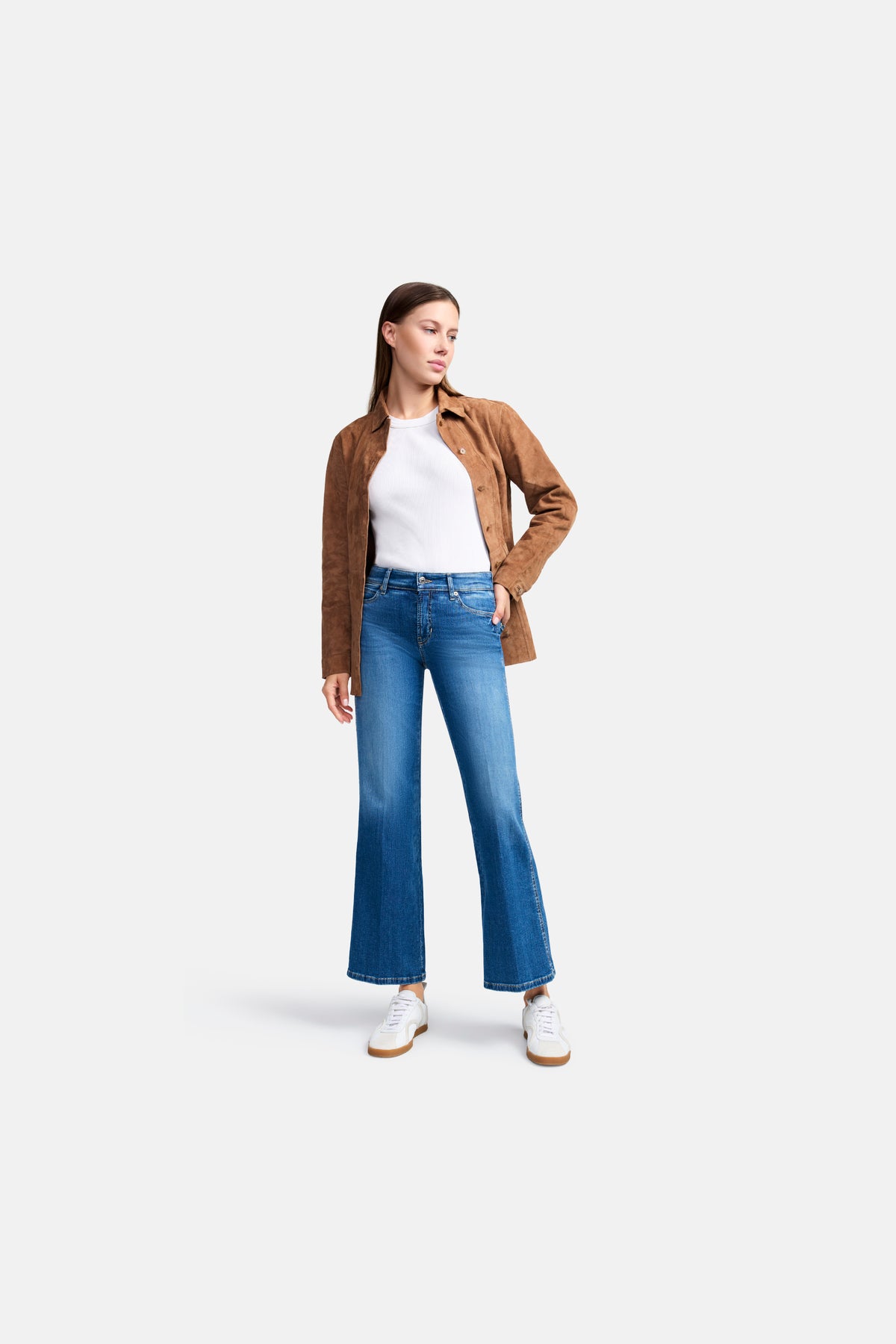 Frau trägt hellblaue, flared Jeans in verkürzter Länge. Die Hose besteht aus 92% Baumwolle, 6% Elastomultiester T400, 2% Elasthan.