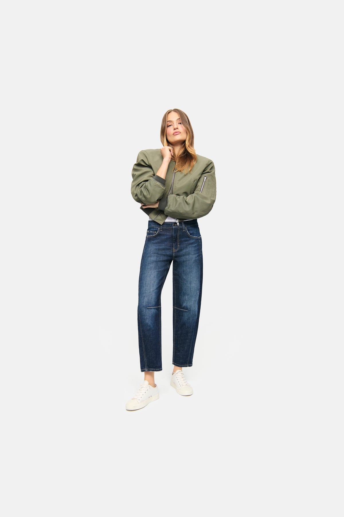 Dunkelblaue O-Shape-Jeans aus 98% Baumwolle und 2% Elasthan, getragen in einem urbanen Setting mit weißem Sneaker.