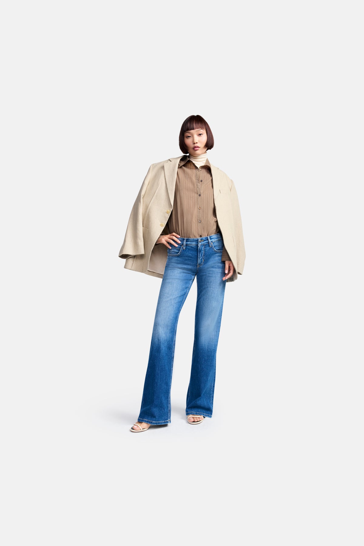 Blaue Jeans mit weitem Bein, aus 92% Baumwolle, 6% Elastomultiester T400 und 2% Elasthan, getragen von einer Person in einem eleganten Outfit.