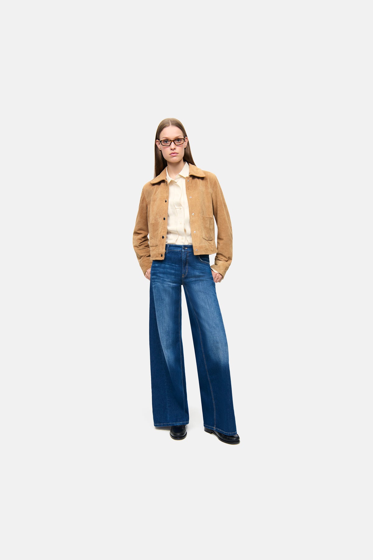Dunkelblaue Palazzo-Jeans aus 92 % Baumwolle, mit seitlichem Patch, getragen von einer Person in urbaner Umgebung.