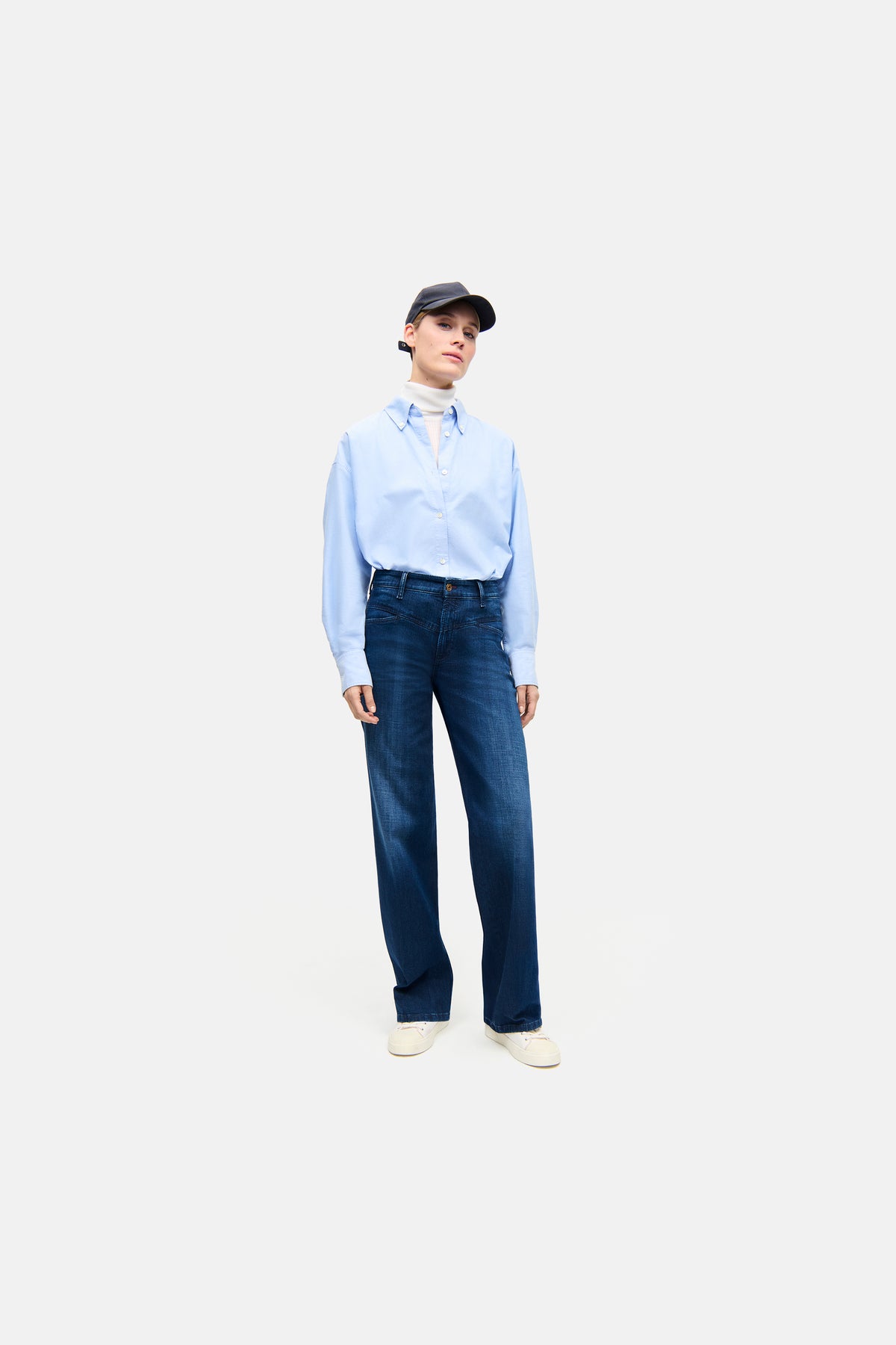Dunkelblaue Wide-Fit-Jeans aus 92% Baumwolle, 6% Elastomultiester T400, 2% Elasthan. Getragen von einer Person mit Hemd und Kappe.