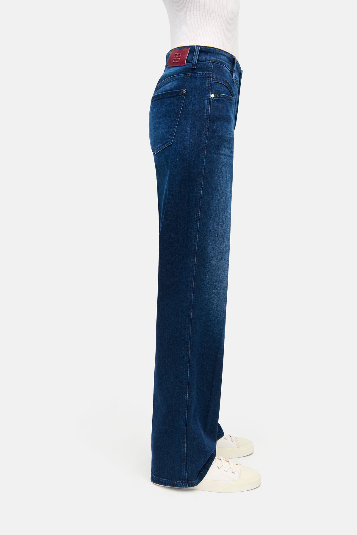 Dunkelblaue Wide-Fit Jeans aus 92% Baumwolle, 6% Elastomultiester, 2% Elasthan. Wird in einer entspannten Alltagsszene getragen.
