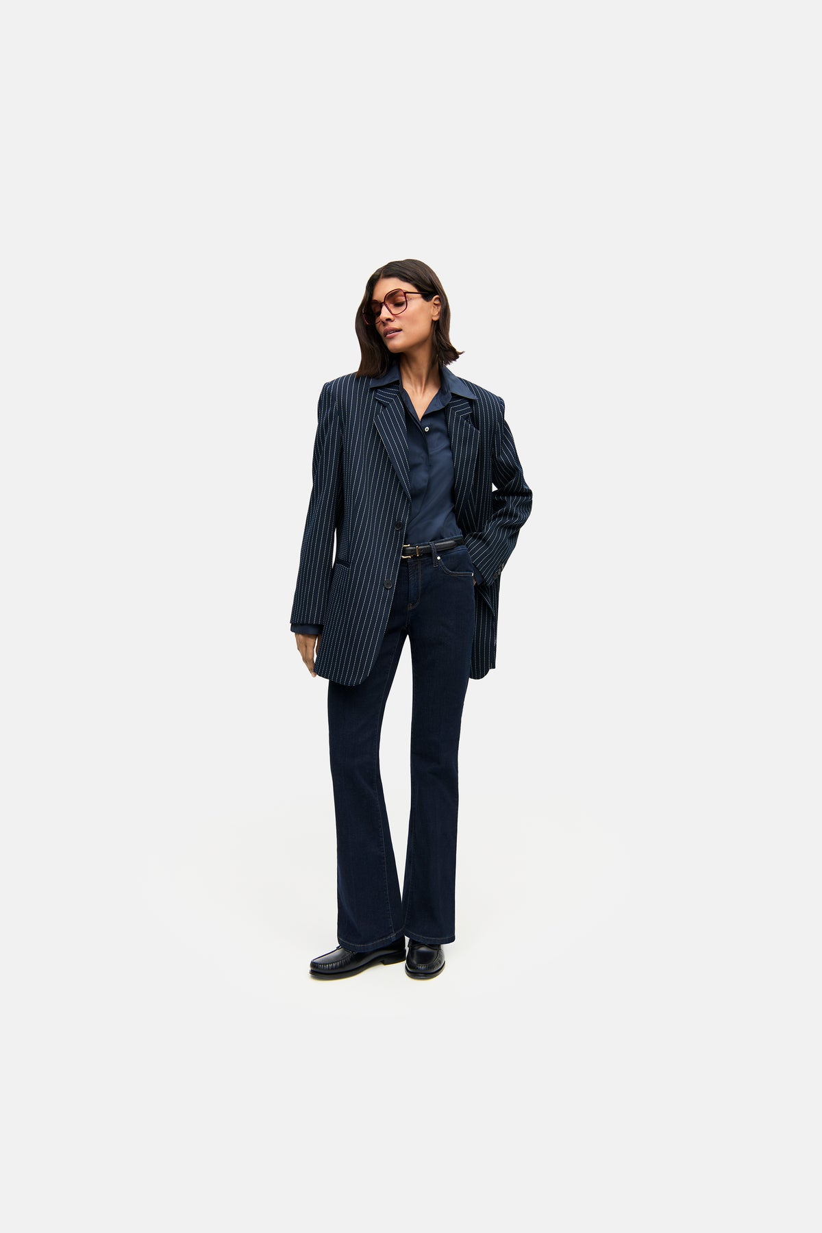 Dunkelblaue flared Fit Jeanshose aus 93% Baumwolle, 5% Polyester, 2% Elasthan, getragen in einer urbanen Umgebung.