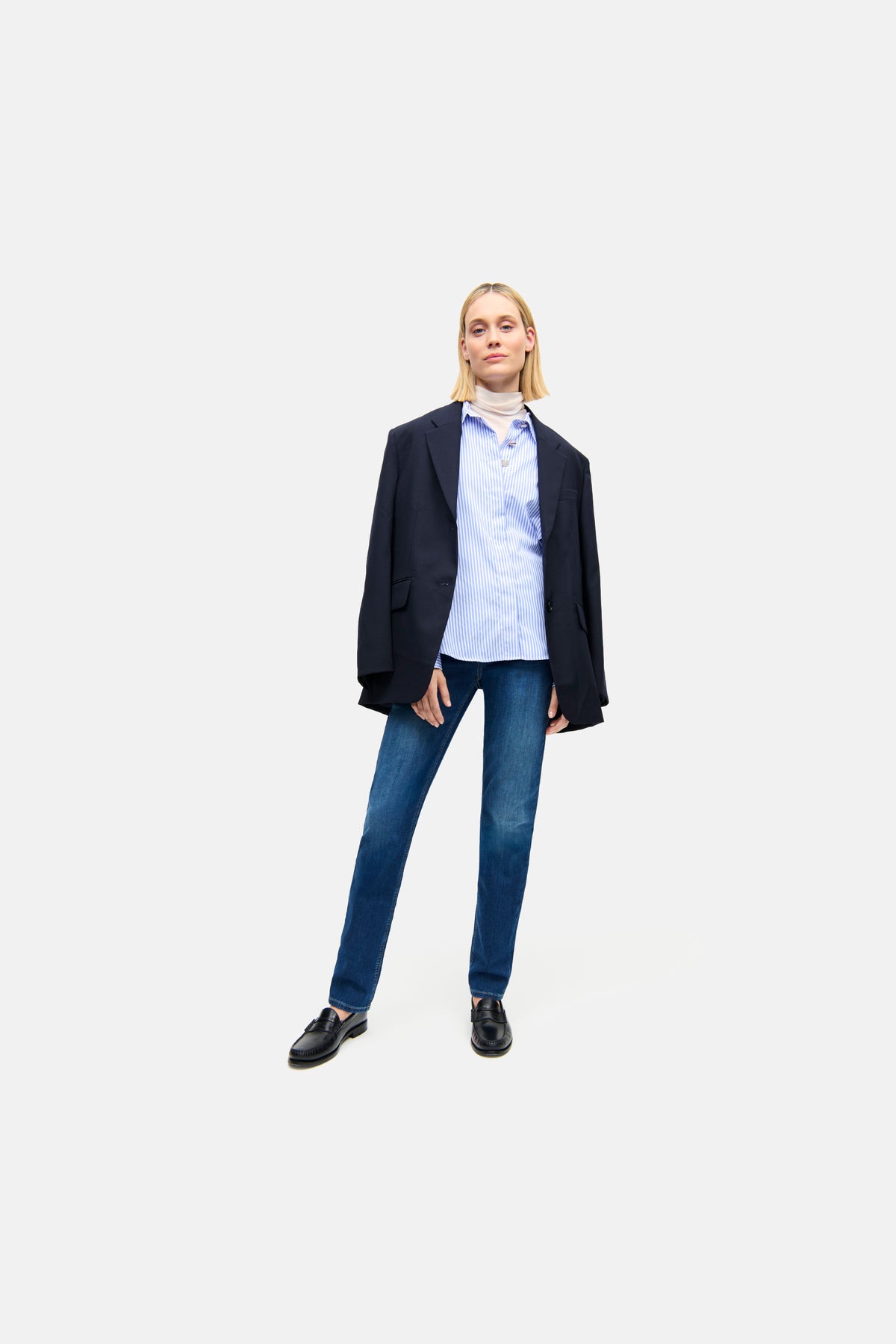 Damen trägt Slim-Fit-Jeans in Blau aus 92% Baumwolle, 6% Elastomultiester T400, 2% Elasthan, kombiniert mit einem Blazer und Hemd.
