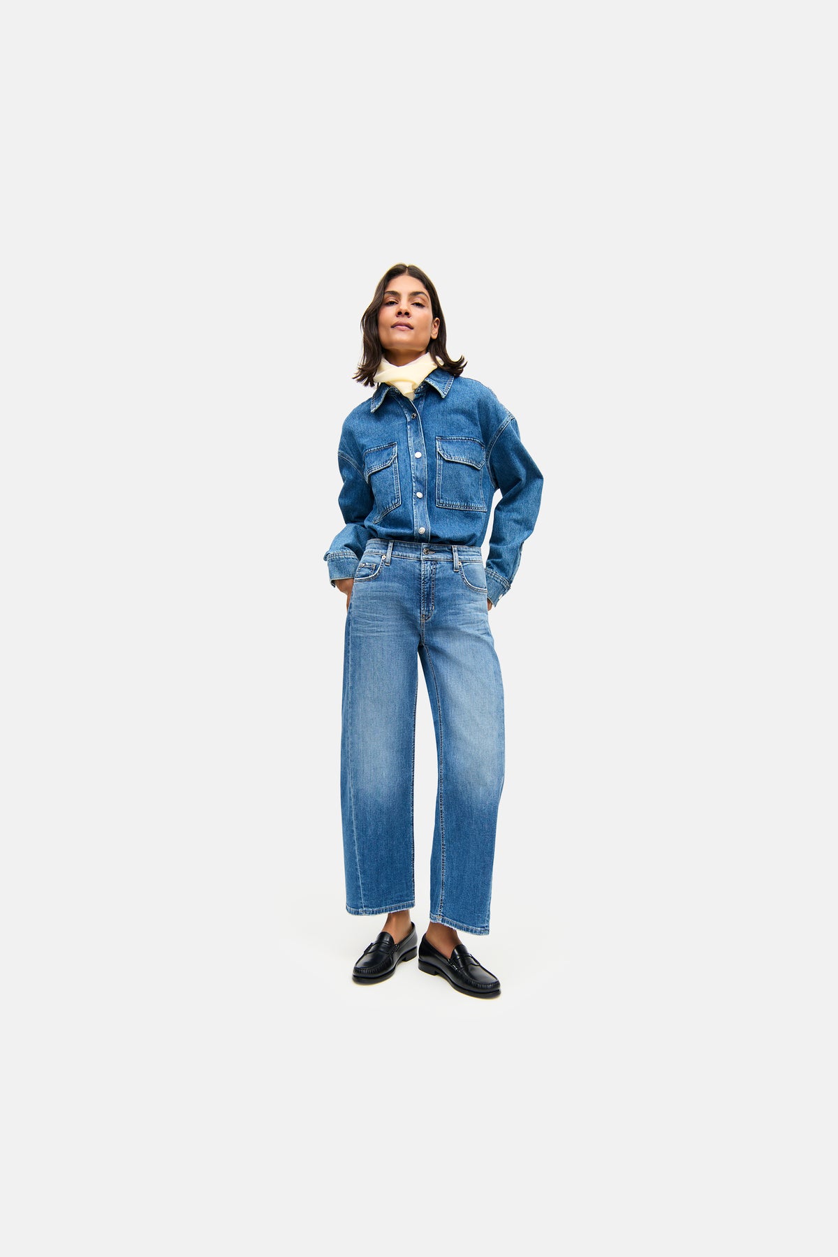 Blaue O-Shape Jeans aus Denim, 92% Baumwolle, 6% Elastomultiester T400, 2% Elasthan, getragen von einer Person in urbanem Umfeld.