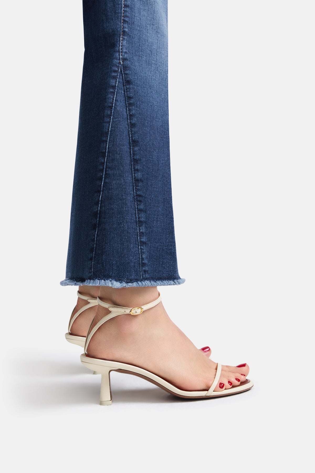 Dunkelblaue, verkürzte Flared Jeans aus 92% Baumwolle, 6% Elastomultiester T400, 2% Elasthan. Offener Saum erkennbar.