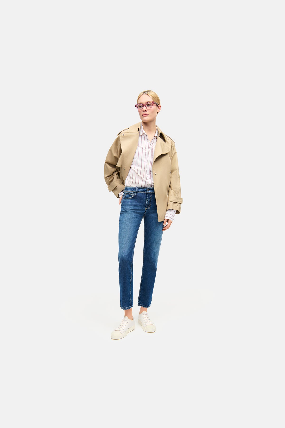 Blaue Slim-Fit-Jeans mit Strass-Details aus 92 % Baumwolle, 6 % Elastomultiester T400, 2 % Elasthan, im urbanen Setting getragen.
