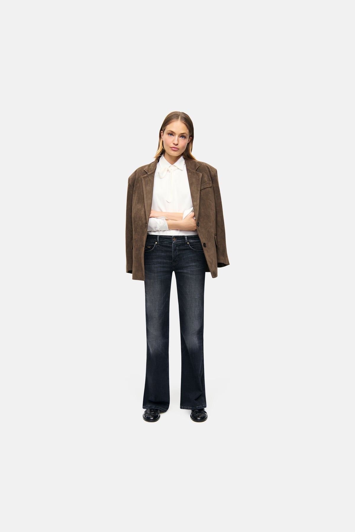 Dunkelblaue Wide-Leg Jeans aus 97% Baumwolle und 3% Elasthan, getragen von einer Person in einem formalen Outfit mit braunem Blazer.