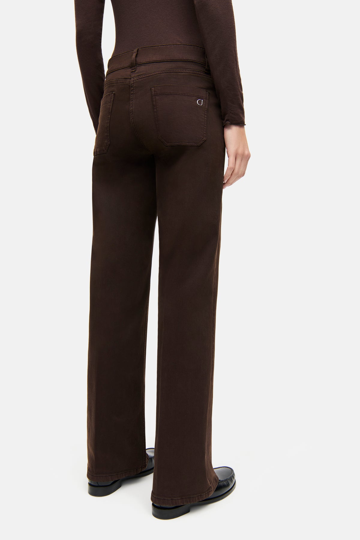 Dunkelbraune Wide-Leg-Jeans aus 94% Baumwolle, 4% Polyester, 2% Elasthan. Person steht, von hinten gezeigt.