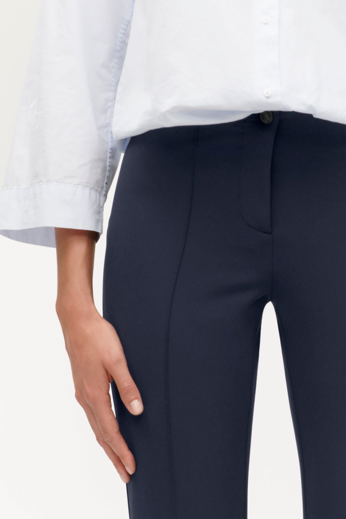 Dunkelblaue Slim-Fit Hose aus 88% Polyamid und 12% Elasthan. Die Hose wird in einem Bürosetting getragen.