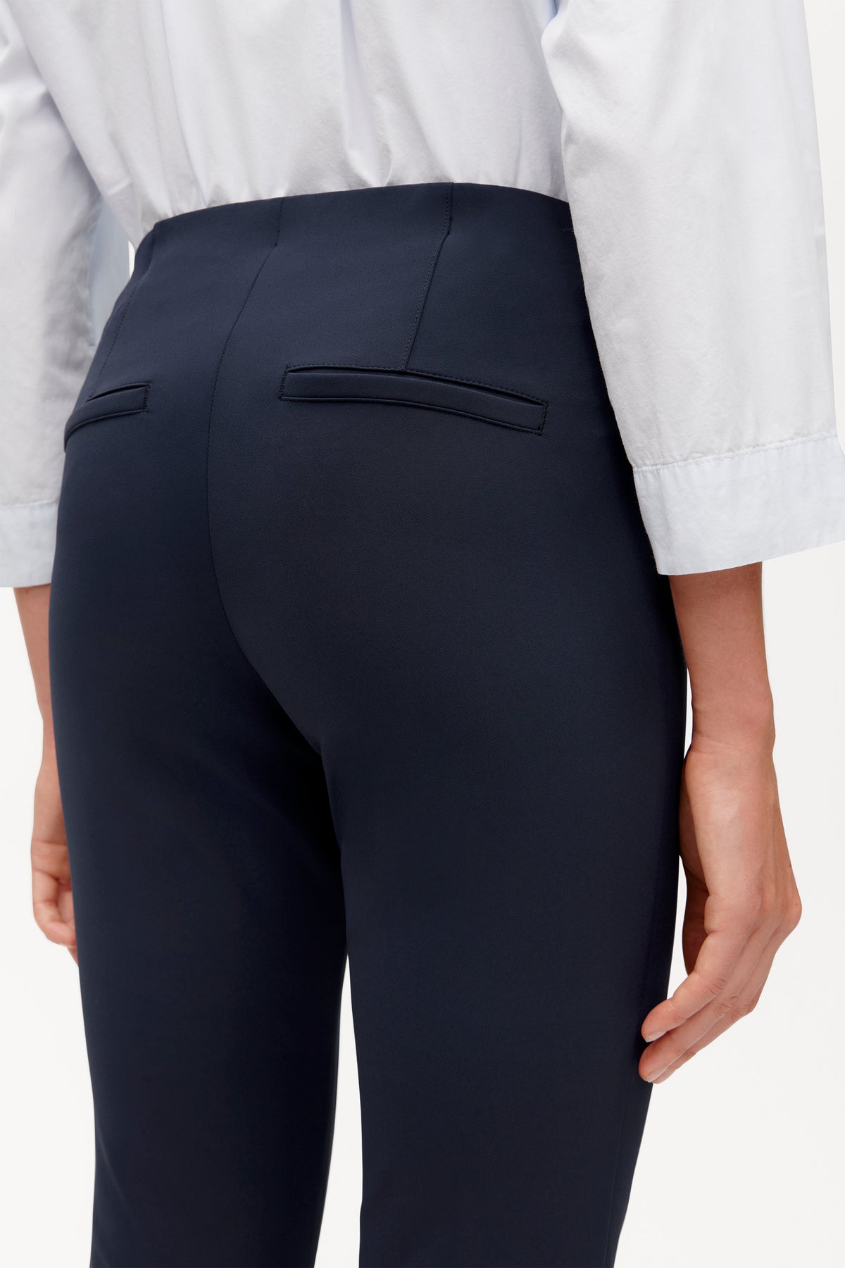 Schwarze Slim-Fit-Hose aus 88 % Polyamid und 12 % Elasthan. Tragesituation in einem formellen Umfeld mit weißem Hemd.