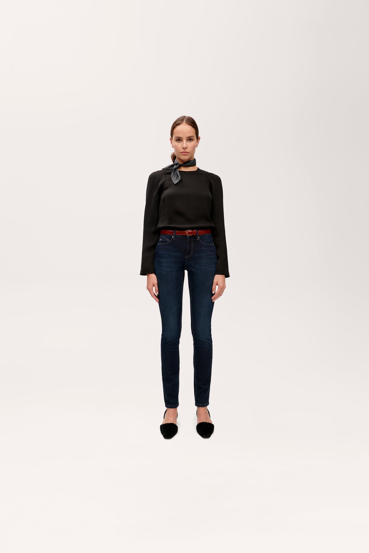 Dunkelblaue Slim Fit Jeans aus 360° Superstretch Denim, Material: 49% Baumwolle, 27% Polyester, 20% Modal, 4% Polyurethan. Die Jeans wird von einer Person getragen, die in einer minimalistischen Umgebung steht.