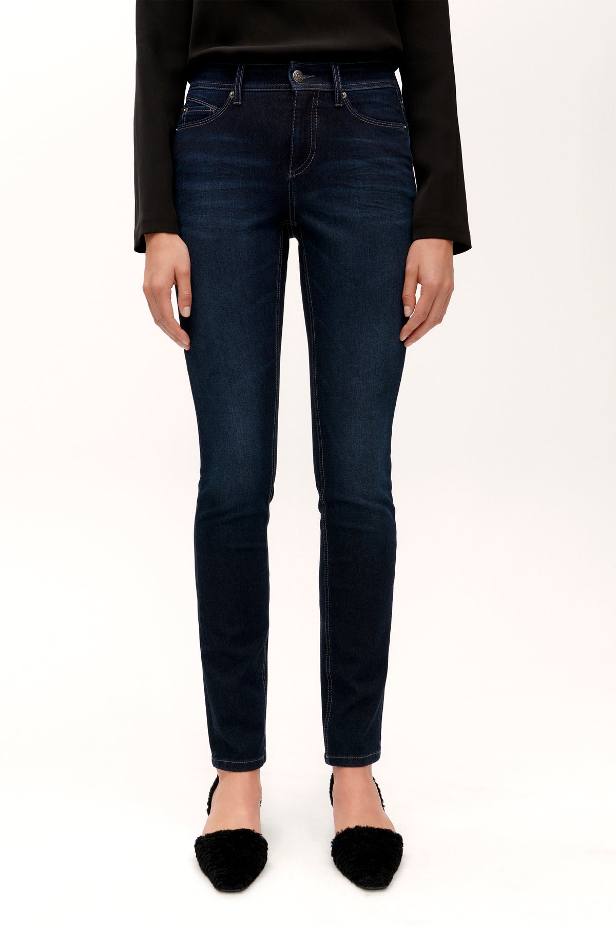 Dunkelblaue Slim-Fit-Jeans aus 49 % Baumwolle, 27 % Polyester, 20 % Modal, 4 % Polyurethan. Getragen in einem Studio-Setting.