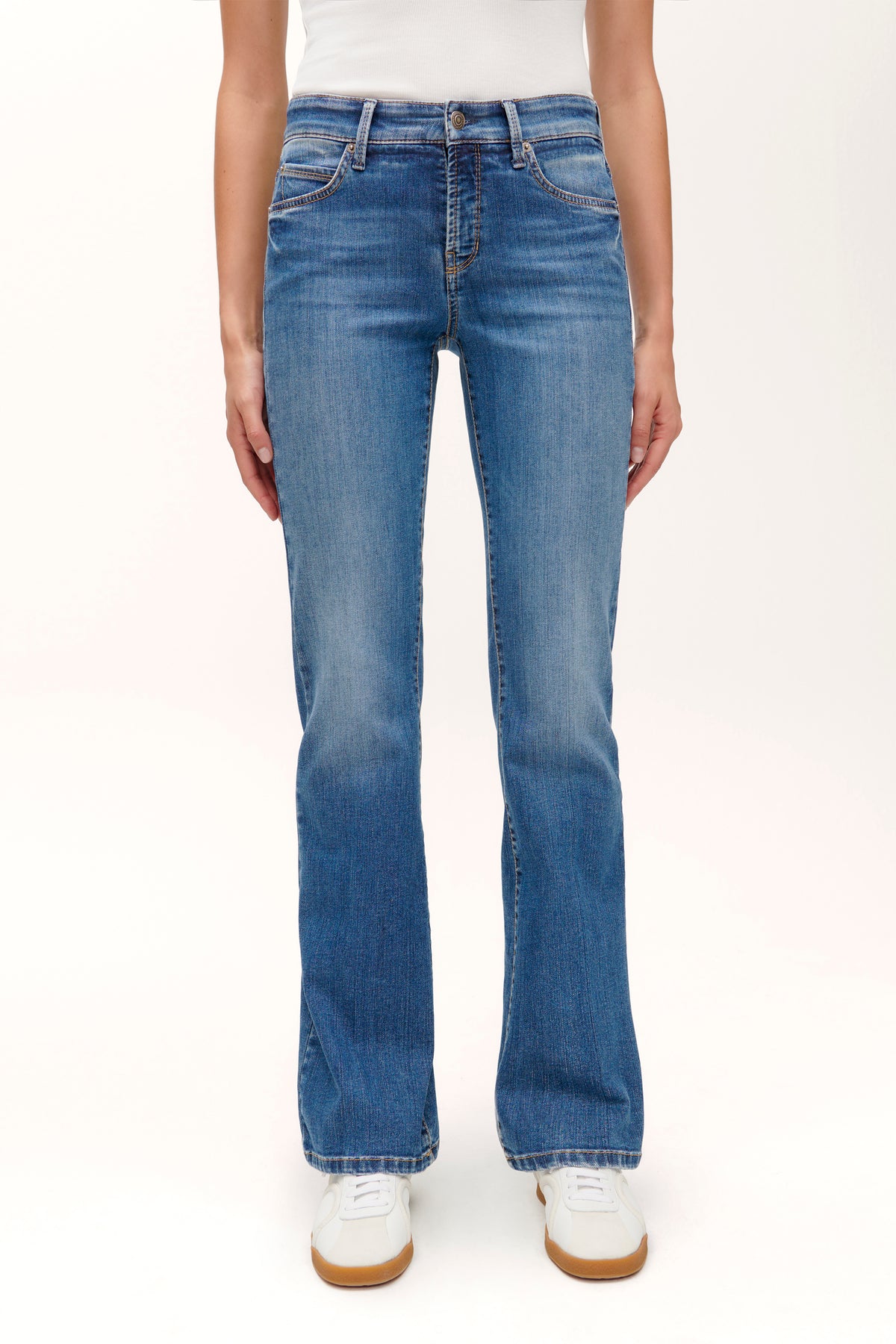 Blaue Flared Jeans aus 92% Baumwolle, 6% Elastomultiester, 2% Elasthan. Getragen in einer Studioaufnahme.