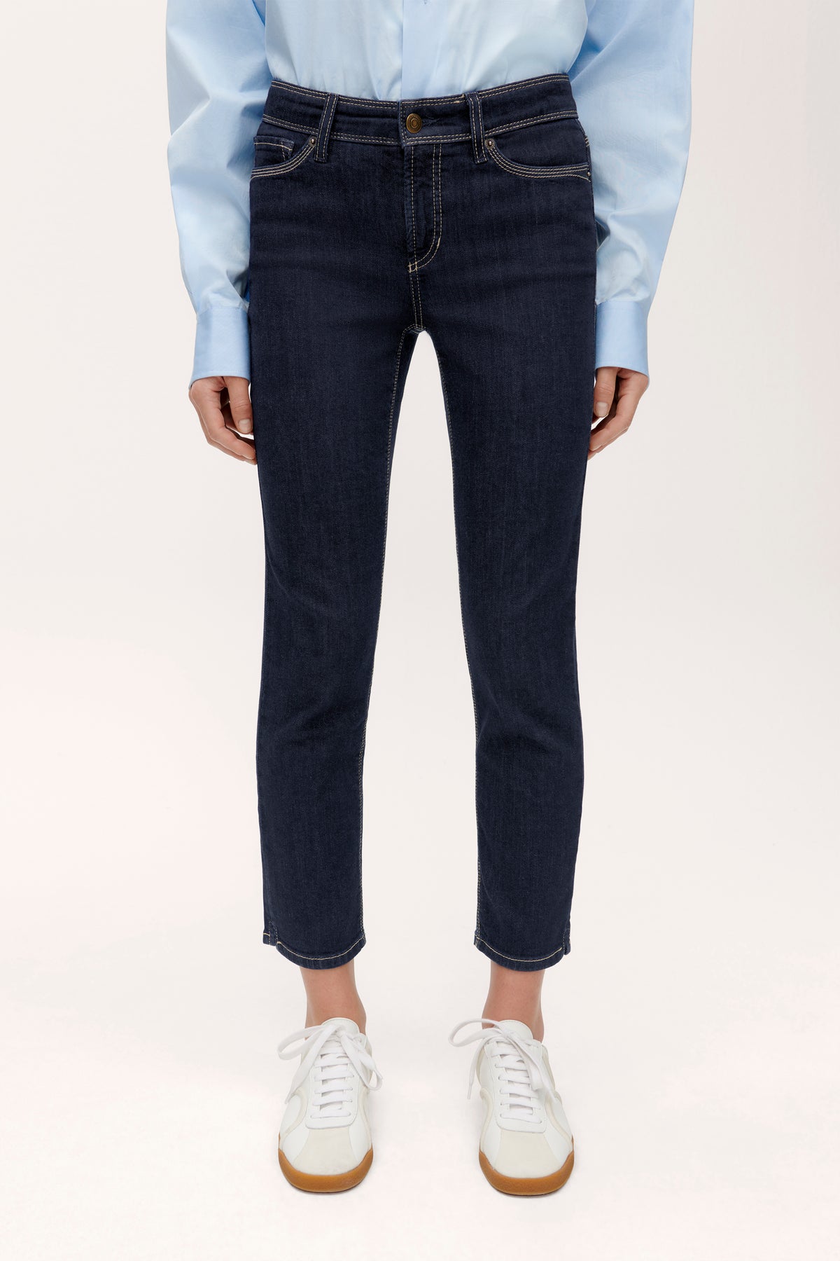 Blaue Slim-Fit-Jeans aus Denim, Material aus 93 % Baumwolle, 5 % Polyester, 2 % Elasthan, getragen in einer Studioaufnahme.