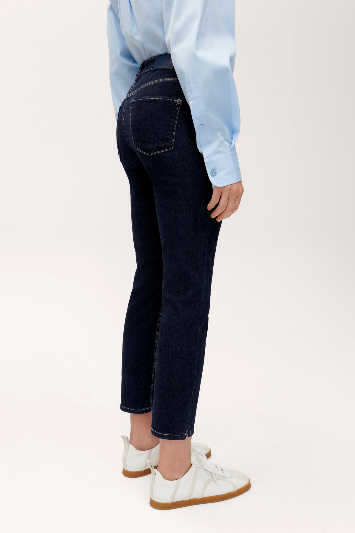 Dunkelblaue Slim-Fit-Jeans aus Baumwollmischung, verkürzte Länge. Getragen im Alltag, kombiniert mit blauem Hemd.