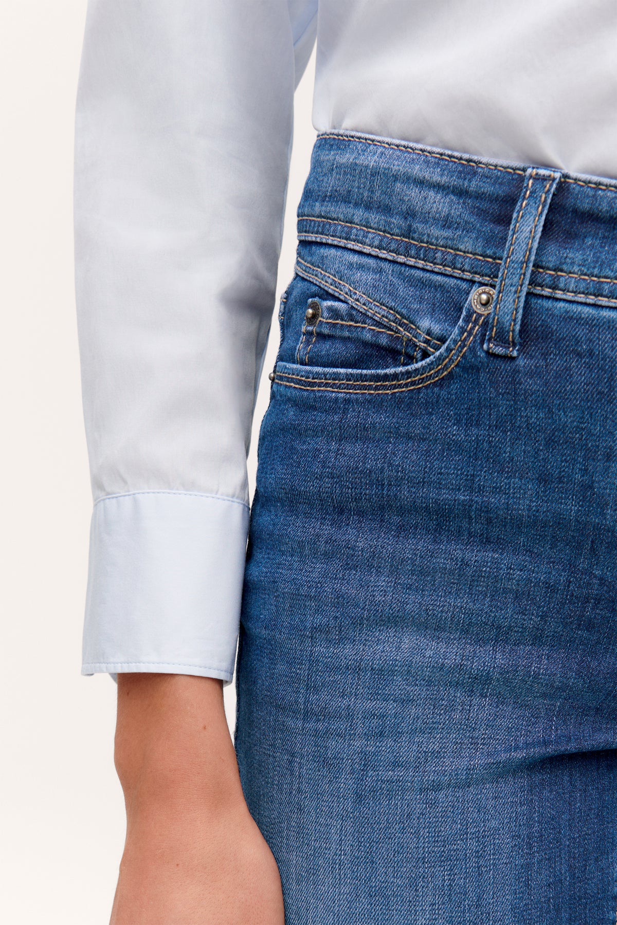 Blaue Slim-Fit Jeans aus 92% Baumwolle, 6% Elastomultiester T400, 2% Elasthan. Getragen mit weißem Hemd im Bürosetting.