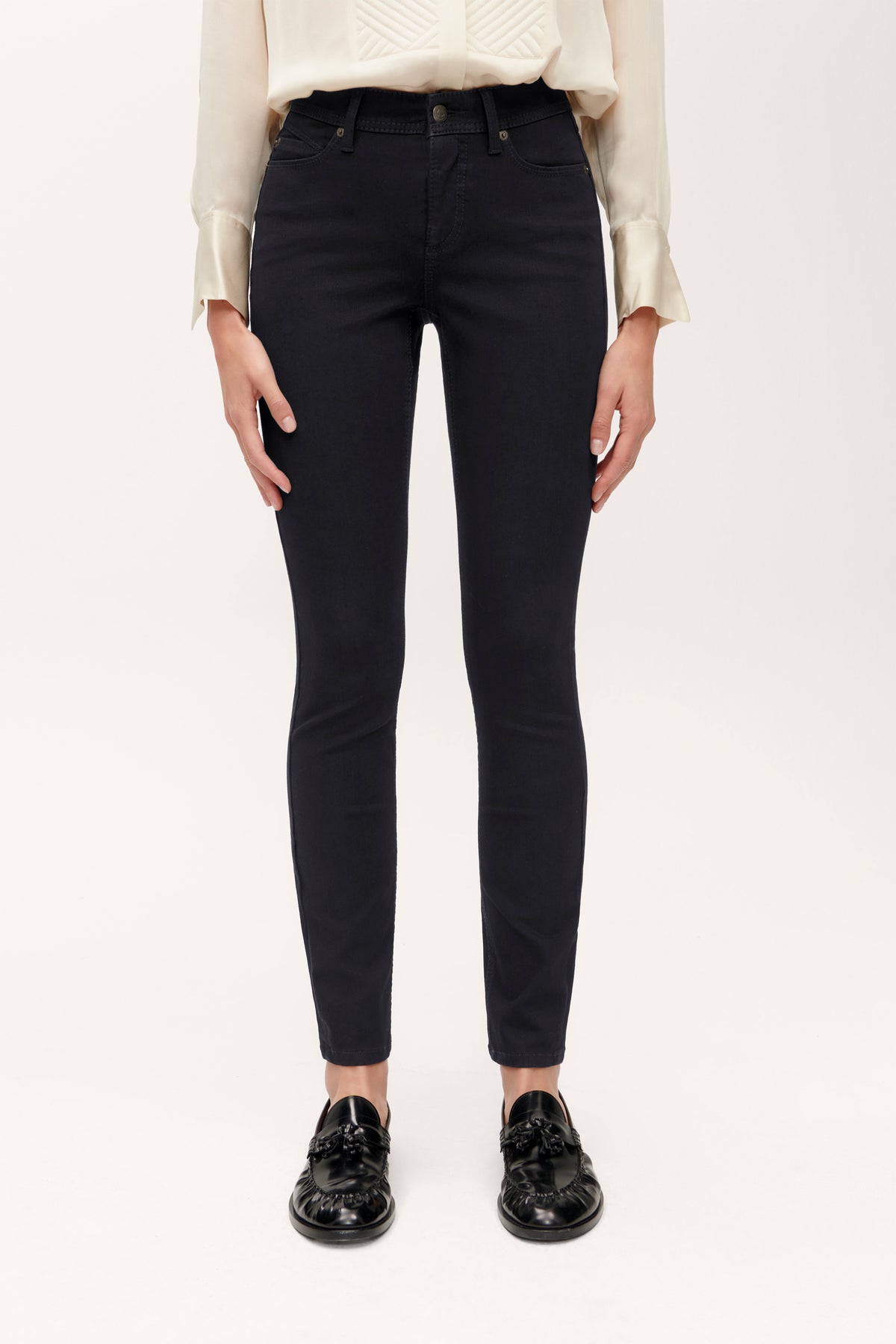 Schwarze Slim Fit Jeans aus 77% Baumwolle, 18% Polybutylen-Terephthalat, 5% Elasthan, getragen von einer Person.