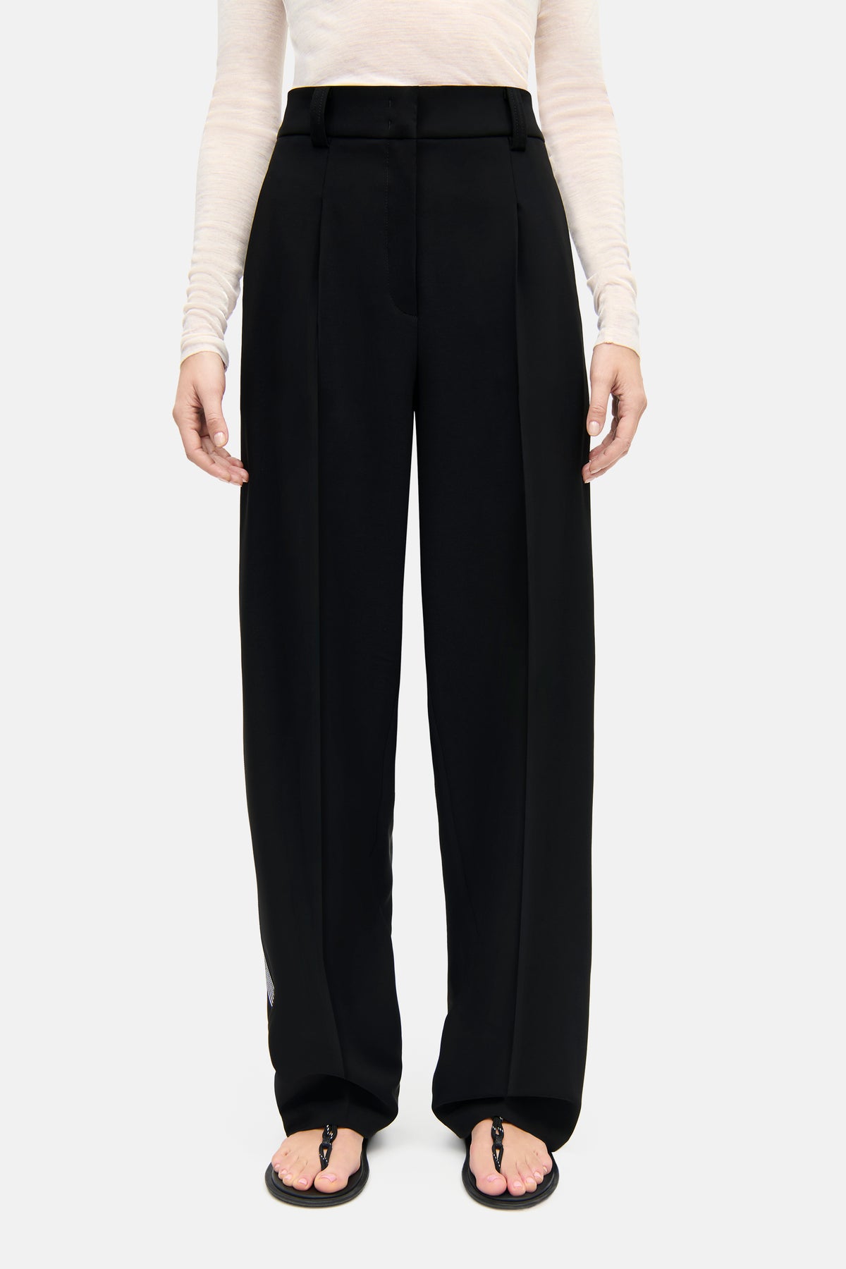 Schwarze O-Shape Hose aus 92% Polyester und 8% Polyurethan, getragen von einer Person in einem lässigen Setting.