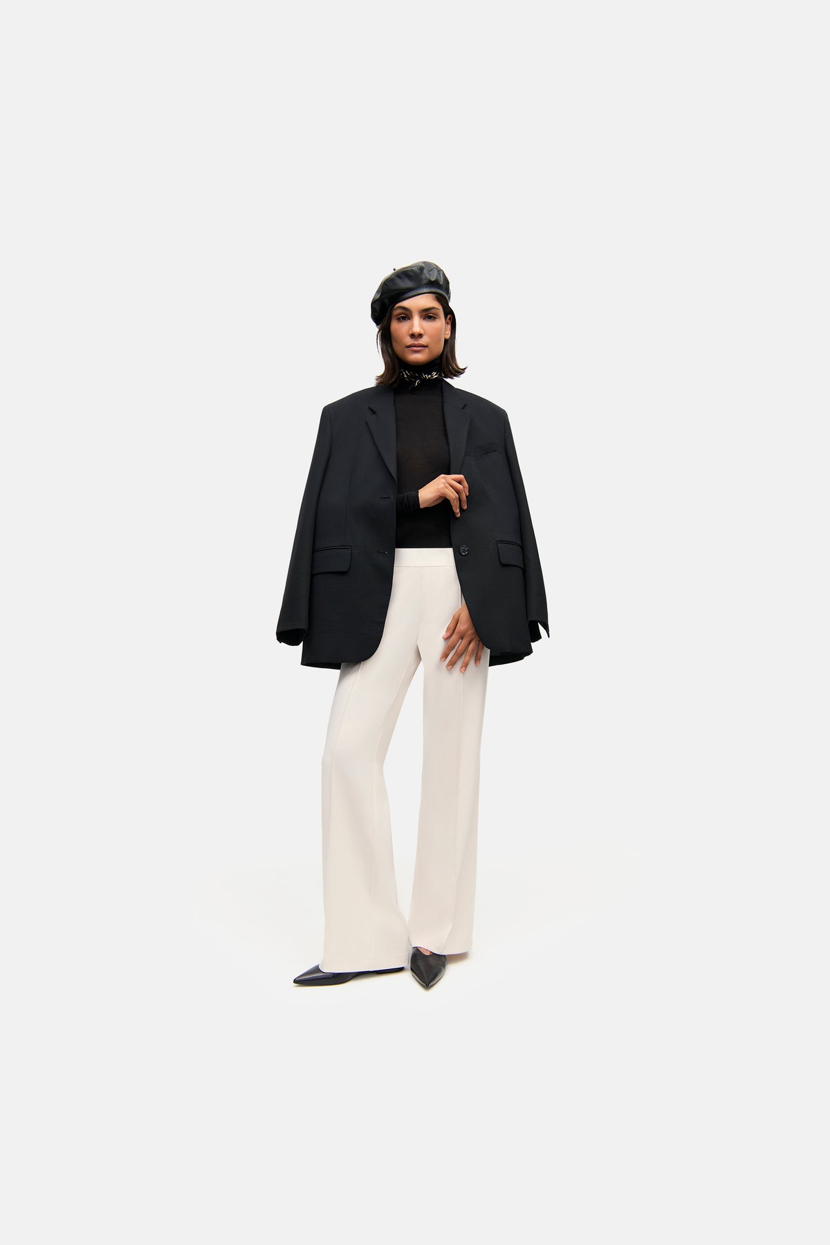 Weite, lange Hose in Elfenbein aus 90% Polyester und 10% Polyurethan, getragen von einer Person mit Blazer und Baskenmütze.