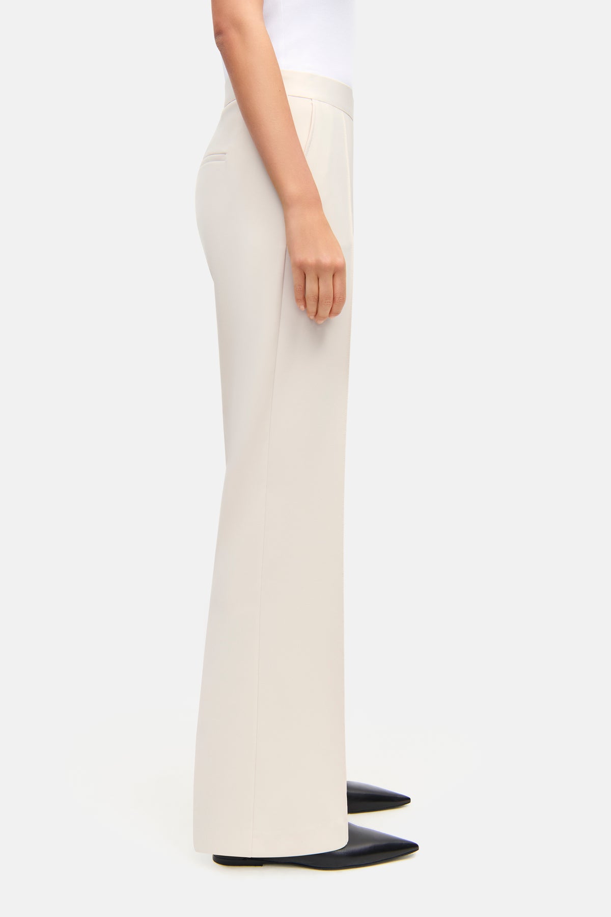 Weite, elfenbeinfarbene Hose aus Polyester-Bistretch, getragen von einer Person, mit elastischem Bund, in modernem Schnitt.