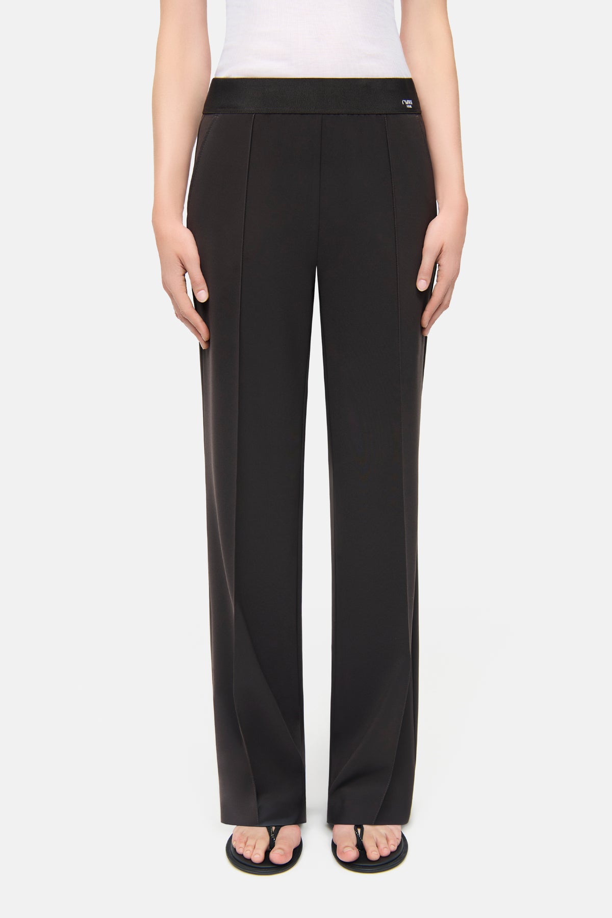 Schwarze Wide-Leg-Hose aus Polyester-Bistretch-Material, getragen in einem schlichten Studio-Setting.