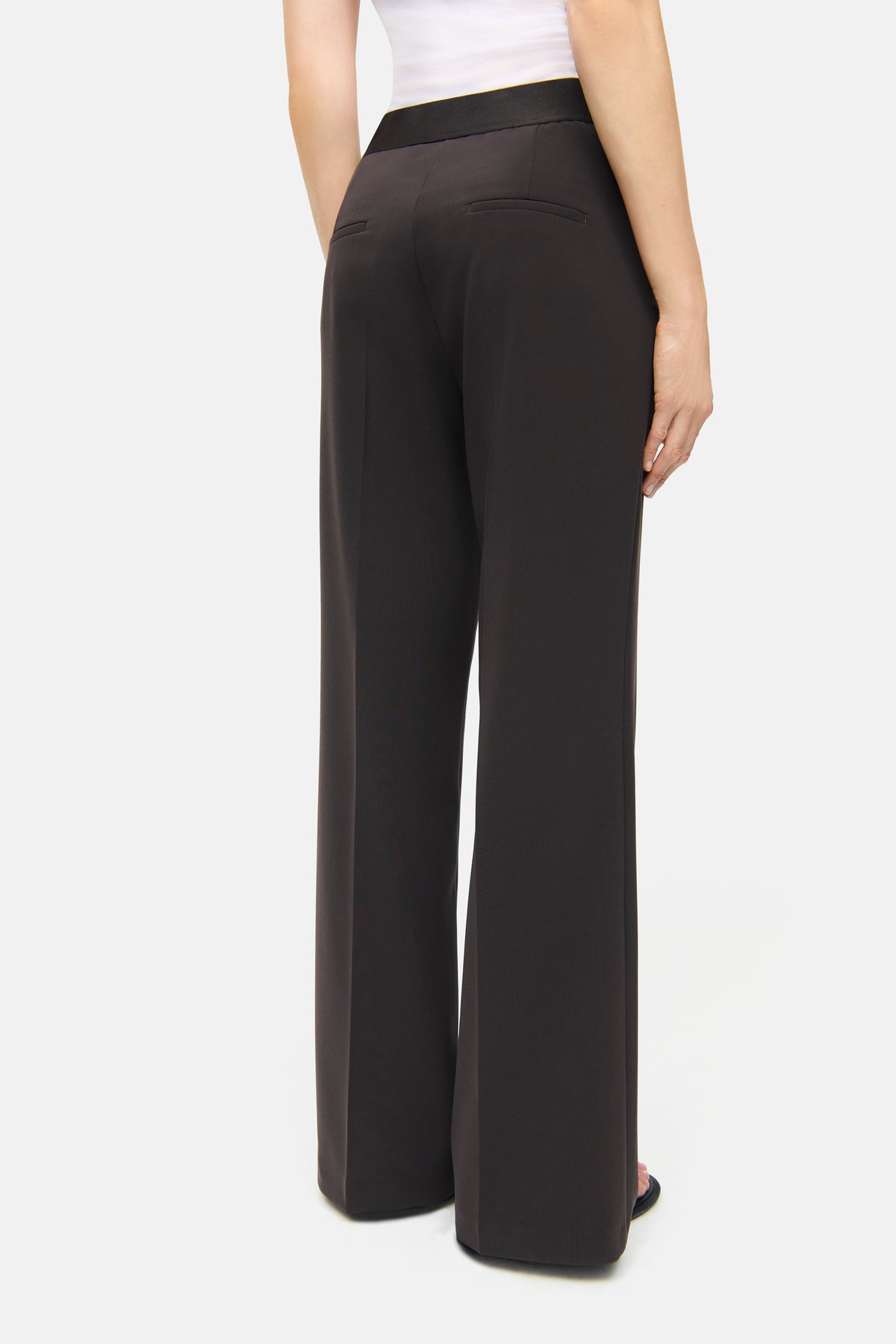 Dunkelbraune Wide-Leg-Hose aus 90% Polyester und 10% Polyurethan. Gummibund, Rückansicht im Innenbereich fotografiert.