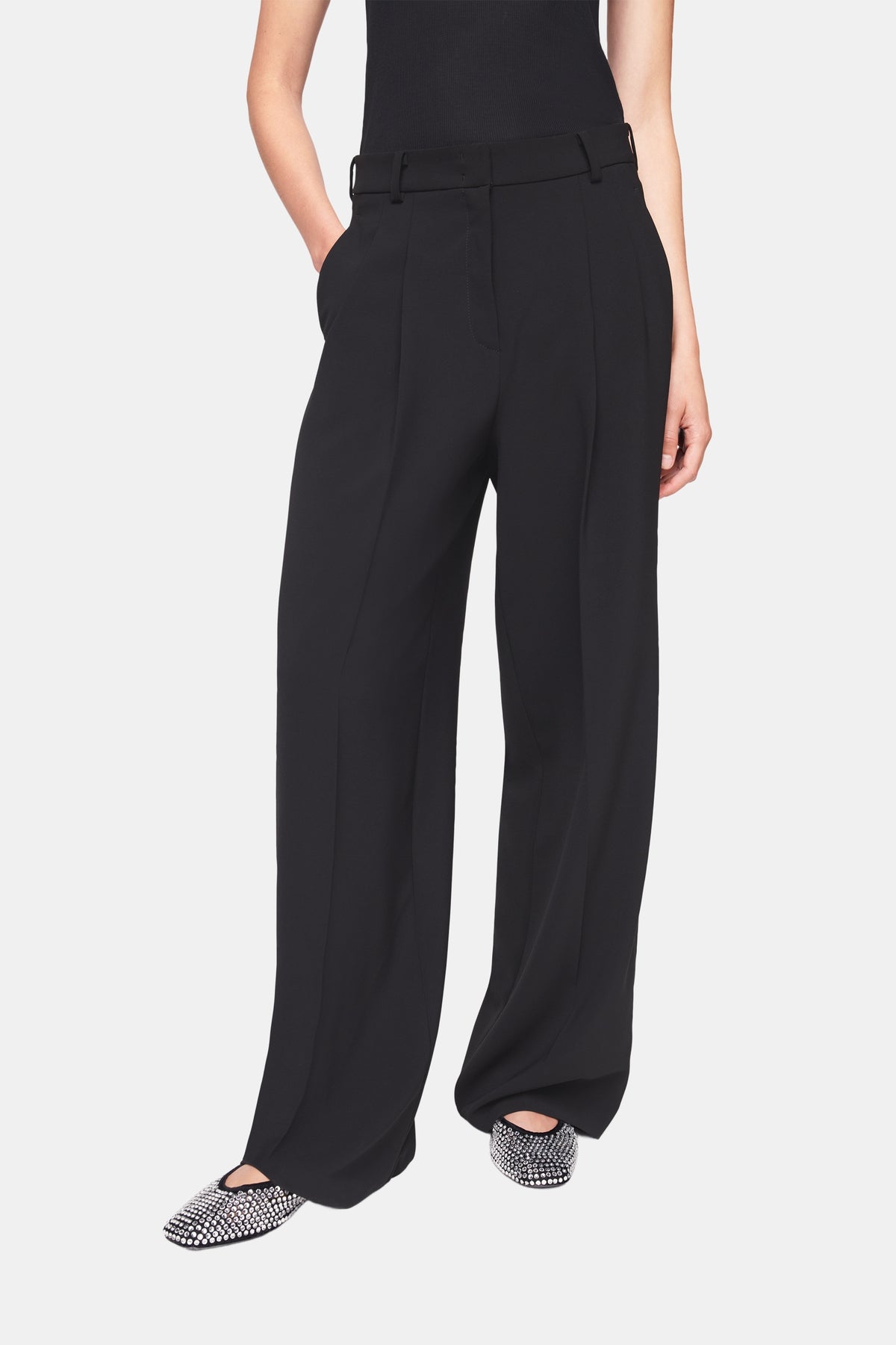 Schwarze Wide-Fit-Hose aus 90% Polyester und 10% Polyurethan. Die Hose hat eine doppelte Bundfalte und weites Bein.