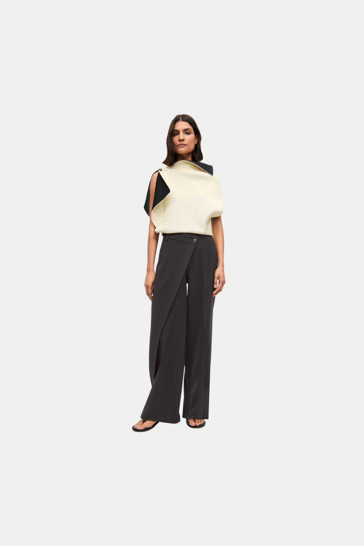 Braune Wide-Leg-Hose aus 90% Polyester und 10% Polyurethan, mit asymmetrischem Bund in urbanem Setting getragen.