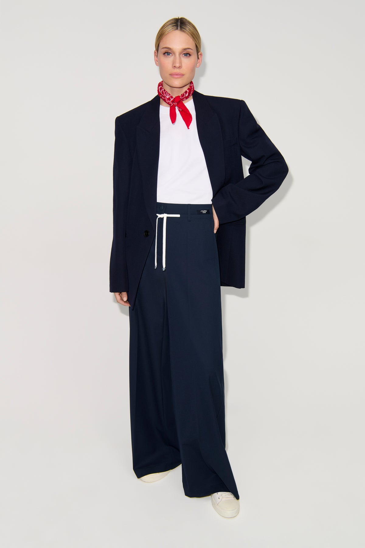 Dunkelblaue Wide Leg Hose aus 67% Polyester, 4% Elasthan und 29% Viskose. Im Geschäftskontext mit Blazer getragen.